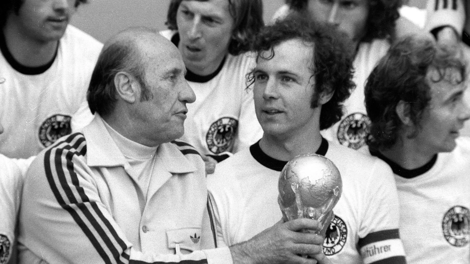 Bildnummer: 01809461 Datum: 07.07.1974 Copyright: imago/WEREK
Weltmeister BR Deutschland - Bundestrainer Helmut Schön (li.) und Franz Beckenbauer (2.v.li.) mit dem WM Pokal; BRD, Endspiel, Vneg, Vsw, quer, close, Trainer, Coach, Nationaltrainer, Nationalcoach, Sieg, Sieger, Siegerfoto, Trophäe, Weltmeisterschaft 1974, Nationalmannschaft, Nationalteam, Nationaltrikot, Länderspiel, Finale München Glück, Freude, Fußball WM Herren Mannschaft Gruppenbild optimistisch Randmotiv Personen Objekte
