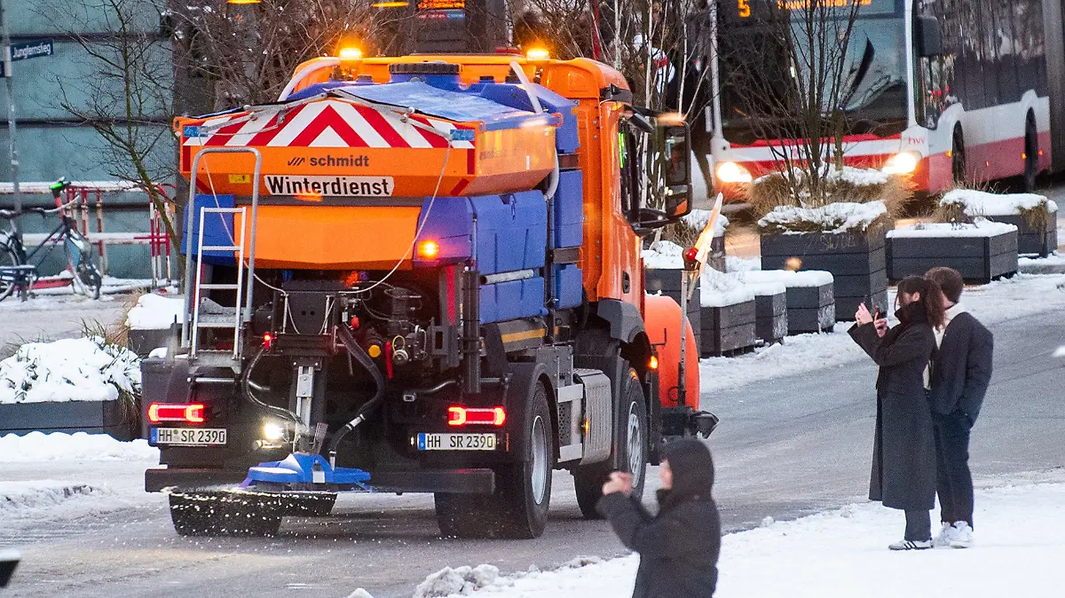 07.01.2024, Hamburg: Ein Fahrzeug vom Winterdienst fährt in der Innenstadt über den Jungfernstieg und streut die Straße. (zu dpa "Plötzliche Glätte löst im Norden zahlreiche Unfälle aus") Foto: Daniel Bockwoldt/dpa +++ dpa-Bildfunk +++