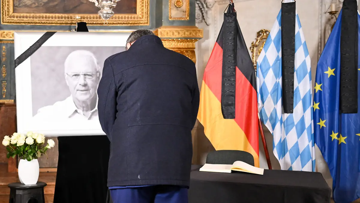 10.01.2024, Bayern, München: Fußball: Markus Söder (CSU), Bayerischer Ministerpräsident, verneigt sich vor dem Porträt von Franz Beckenbauer, nachdem er sich ins Kondolenzbuch der bayerischen Staatsregierung in der Hofkapelle der Residenz eingetragen hat. Beckenbauer ist am Sonntag, 07.01.2024 im Alter von 78 Jahren gestorben. Foto: Tobias Hase/dpa - ACHTUNG: Nur zur redaktionellen Verwendung im Zusammenhang mit einer Berichterstattung über den Tod von Beckenbauer und nur mit vollständiger Nennung des vorstehenden Credits; nur volles Format, keine Ausschnitte, kein crop +++ dpa-Bildfunk +++