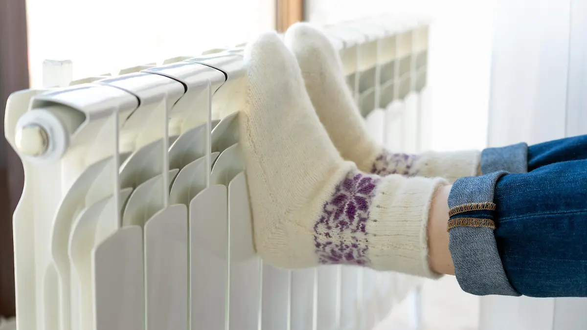 Woman warming up with feet on heater