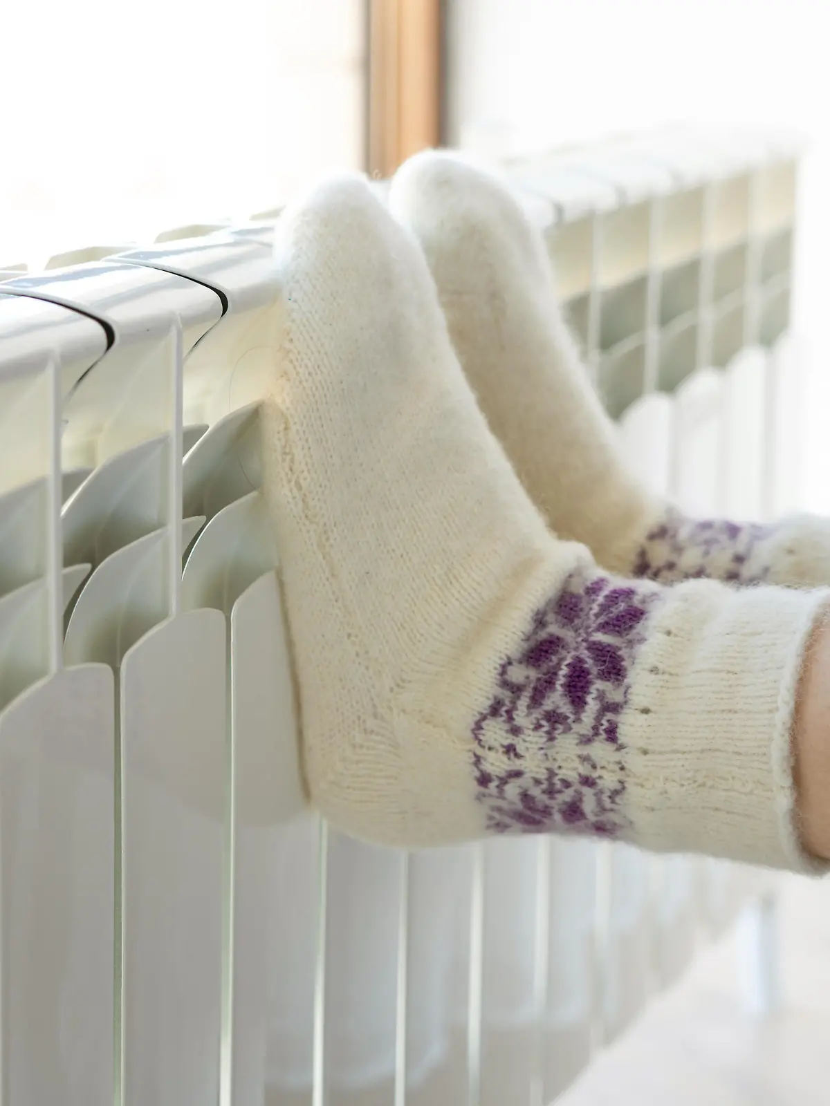 Woman warming up with feet on heater