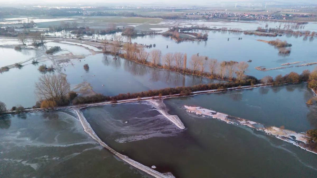 09.01.2024, Niedersachsen, Laatzen: Wasser vom über die Ufer getretenen Fluss Leine steht in der Leinemasch südlich von Hannover. Temperaturen deutlich unter dem Gefrierpunkt verwandeln die überfluteten Wiesen und Felder derzeit zu riesige Eisflächen. Foto: Julian Stratenschulte/dpa +++ dpa-Bildfunk +++