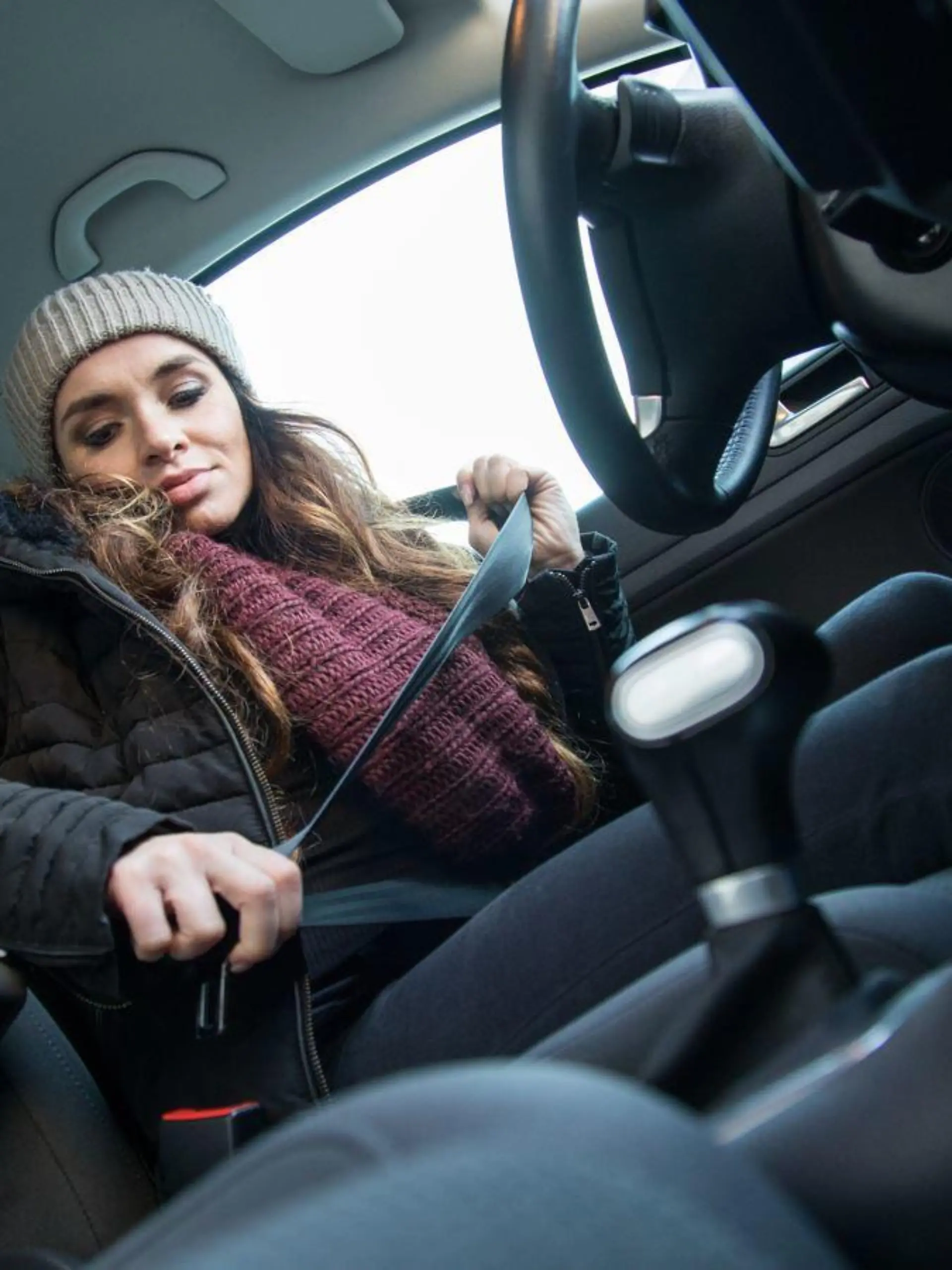 Frau trägt dicke Jacke im Auto.