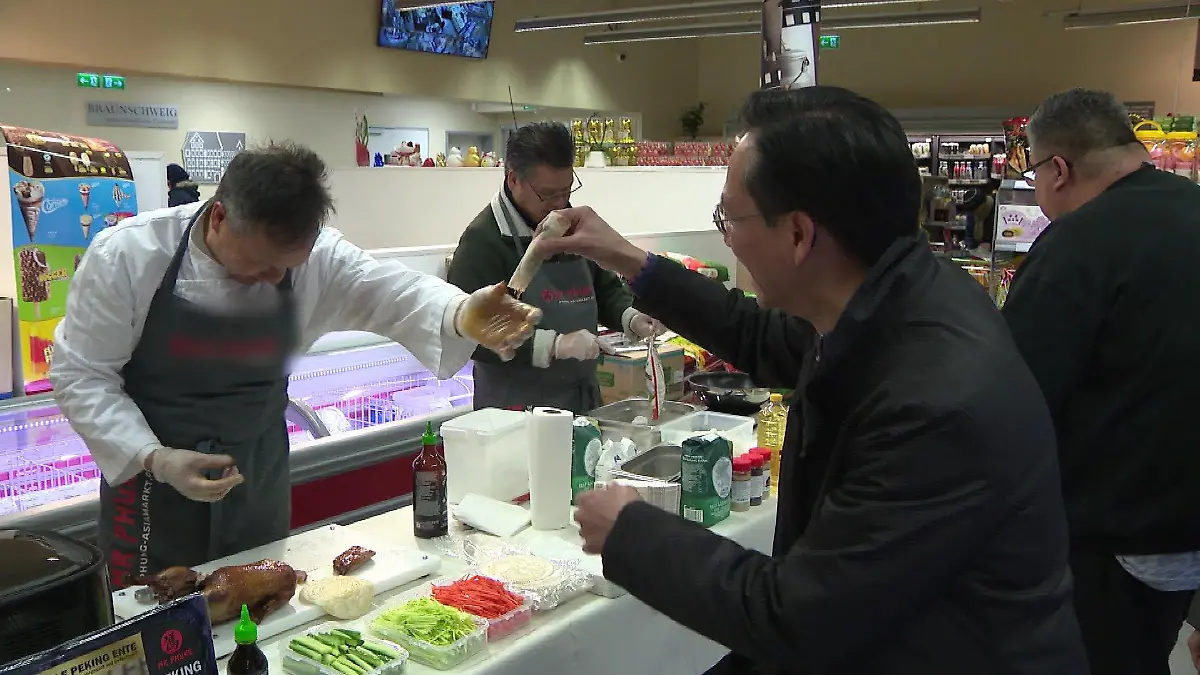 Ly Phung und sein Kollege kochen für ihre Kunden.