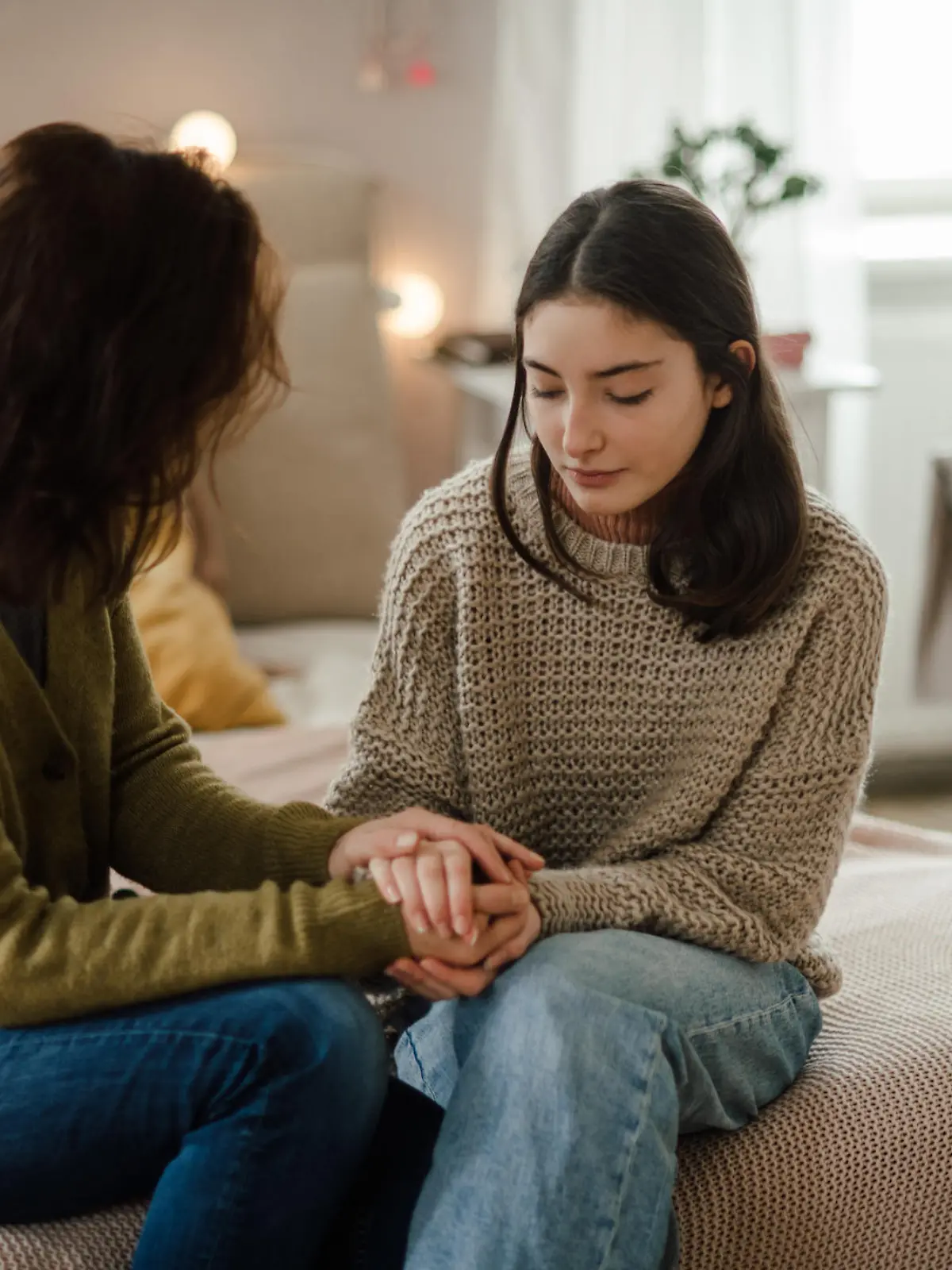 Teenage girl sharing problems with her mother in the room.