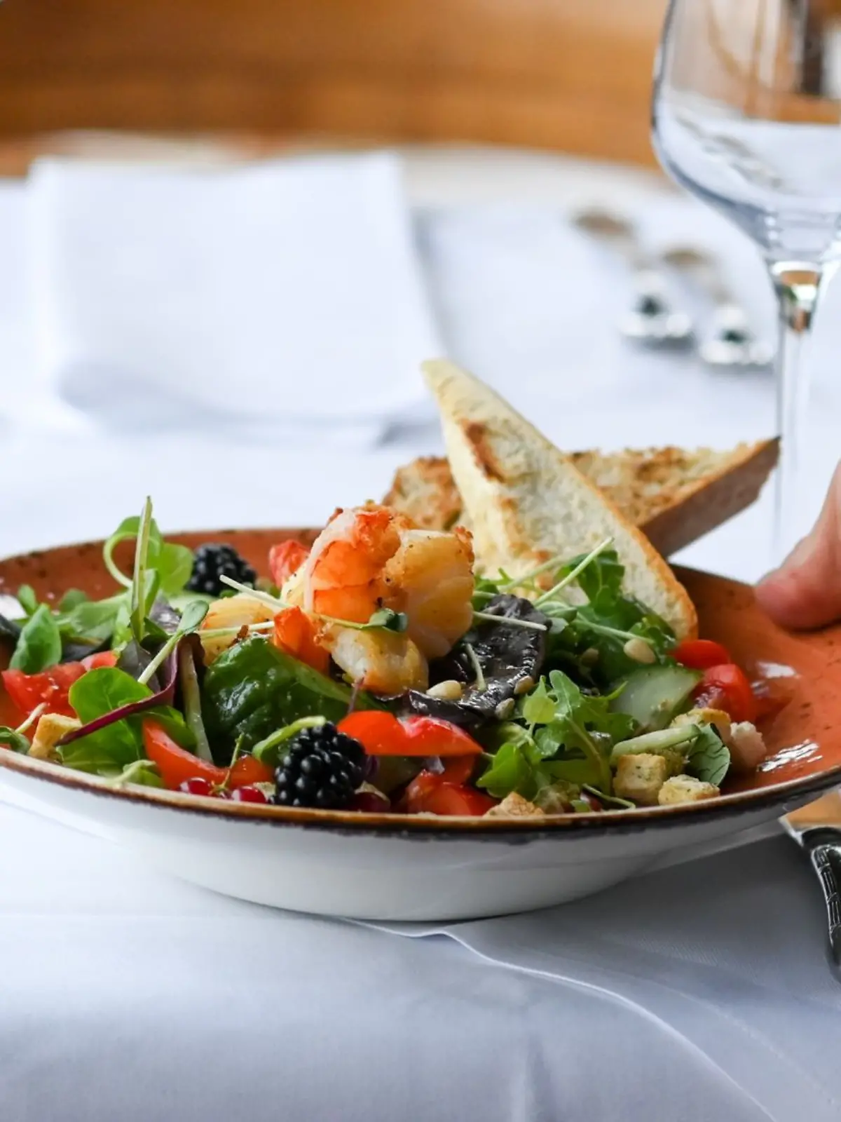 Ein Kellner serviert einen Salatteller in einem Restaurant.