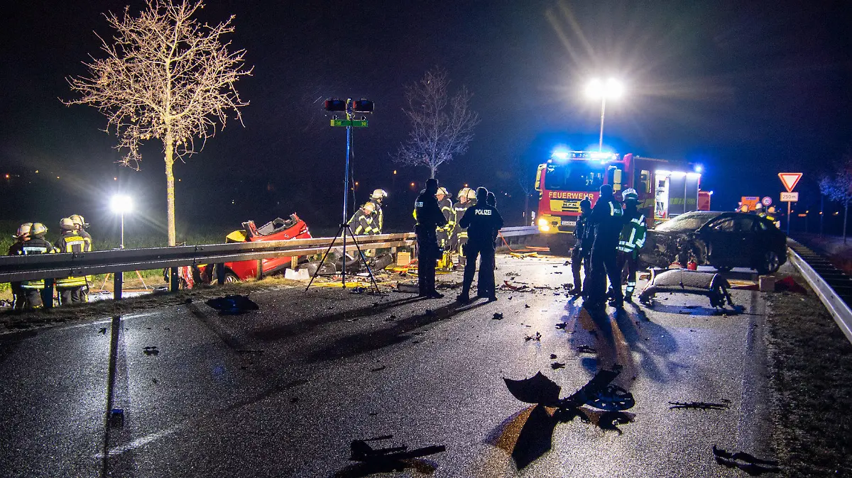 14.01.2024, Nordrhein-Westfalen, Weilerswist: Helfer stehen am frühen Morgen an einer Unfallstelle auf einer Straße, die mit Trümmern übersät ist. Ein 42 Jahre alter Mann ist am frühen Sonntagmorgen auf der Landstraße bei Weilerswist (Kreis Euskirchen) ums Leben gekommen. Er war Polizeiangaben zufolge mit seinem Auto frontal mit einem entgegenkommenden Fahrzeug zusammengeprallt. Der andere Fahrer wurde schwer verletzt und kam in ein Krankenhaus. Foto: Sebastian Klemm/Presse-Eifel /dpa +++ dpa-Bildfunk +++