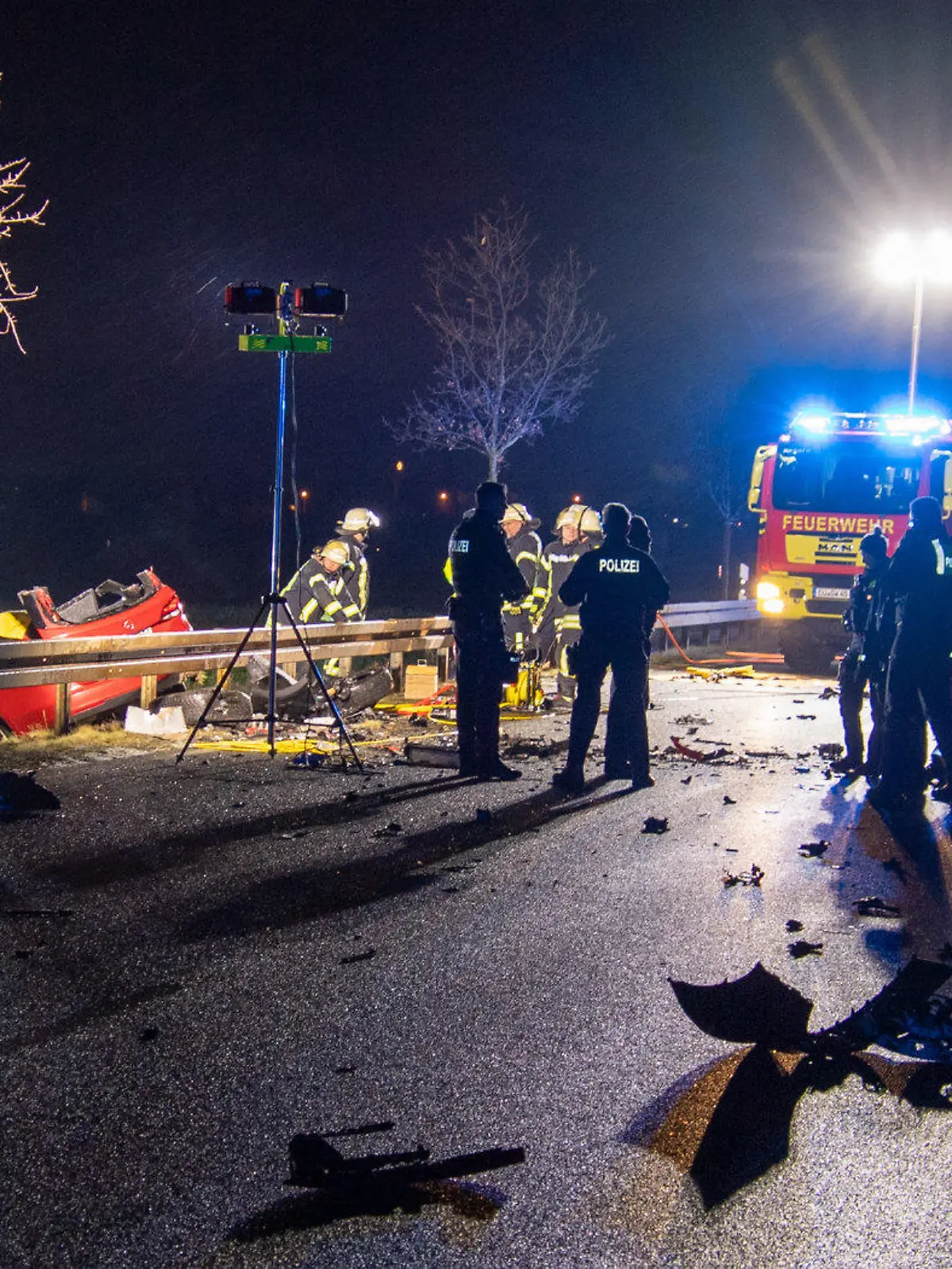 14.01.2024, Nordrhein-Westfalen, Weilerswist: Helfer stehen am frühen Morgen an einer Unfallstelle auf einer Straße, die mit Trümmern übersät ist. Ein 42 Jahre alter Mann ist am frühen Sonntagmorgen auf der Landstraße bei Weilerswist (Kreis Euskirchen) ums Leben gekommen. Er war Polizeiangaben zufolge mit seinem Auto frontal mit einem entgegenkommenden Fahrzeug zusammengeprallt. Der andere Fahrer wurde schwer verletzt und kam in ein Krankenhaus. Foto: Sebastian Klemm/Presse-Eifel /dpa +++ dpa-Bildfunk +++