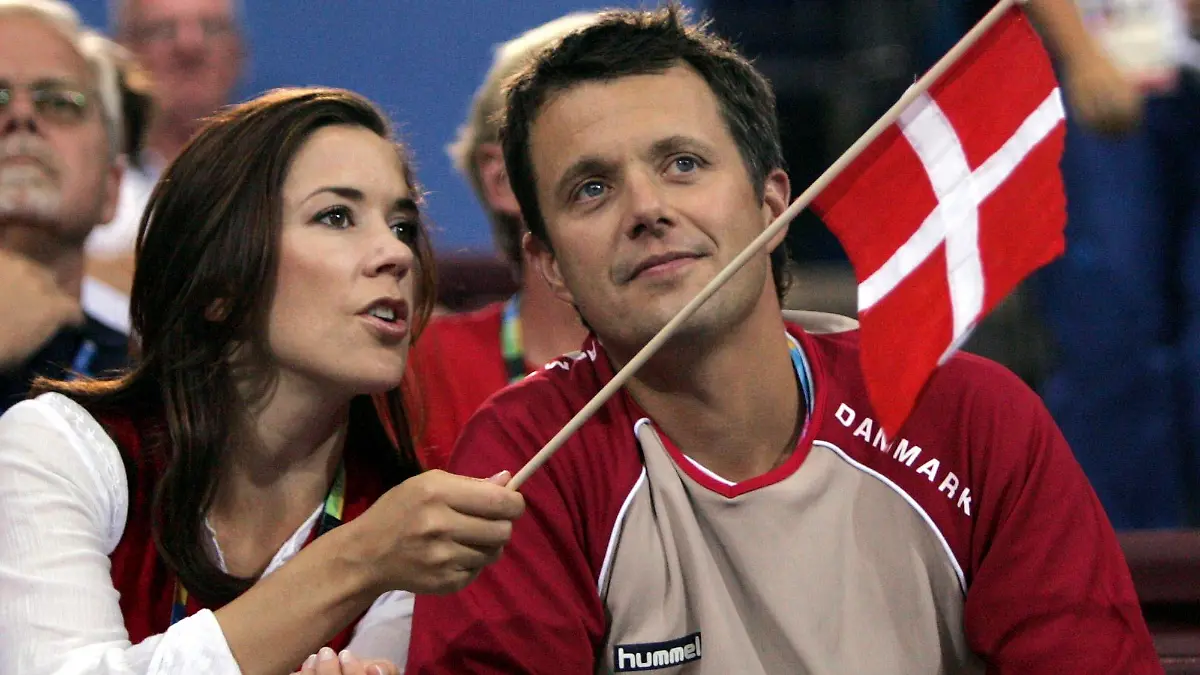 ARCHIV - 15.08.2004, Griechenland, Athen: Kronprinz Frederik (r), und Kronprinzessin Mary von Dänemark sprechen vor dem Beginn des Handballspiels der olympischen Gruppe B der Frauen zwischen Dänemark und Frankreich im Faliro-Sportpavillon bei den Olympischen Spielen 2004. Dänemark erhält an diesem Sonntag ein neues Staatsoberhaupt. Zwei Wochen nach ihrer überraschenden Rücktrittsankündigung dankt die langjährige Königin Margrethe II. (83) offiziell ab und macht somit Platz für ihren Sohn Kronprinz Frederik (55). Foto: Candrew Medichini/AP +++ dpa-Bildfunk +++