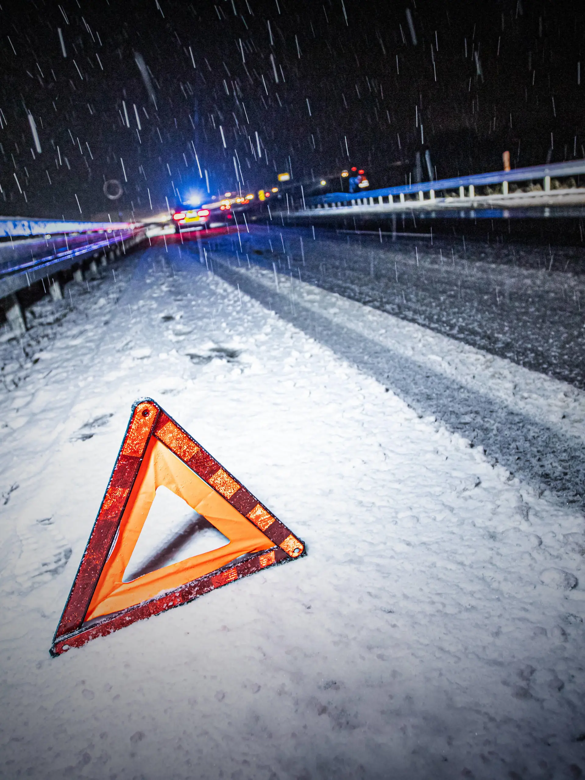 Schneechaos im Ostalbkreis, Symbolbild von einem Warndreieck im Schnee, im Hintergrund sichert die Polizei einen Glätteunfall ab. Essingen *** Snow chaos in the Ostalbkreis, symbolic picture of a warning triangle in the snow, in the background the police secures a slippery road accident from Essingen Copyright: xSimonxAdomatx 