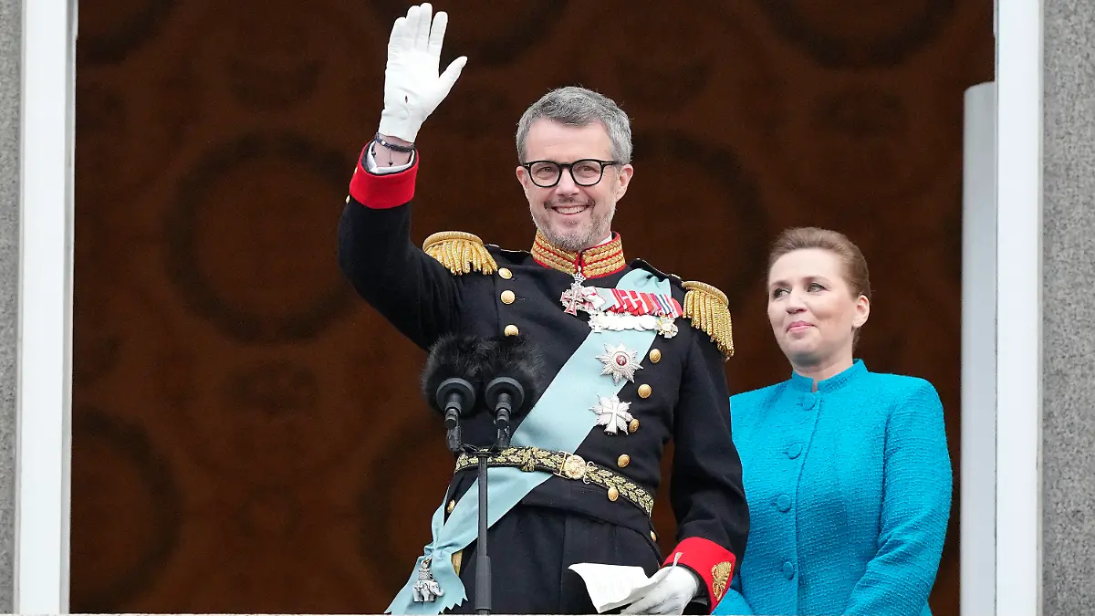 14.01.2024, Dänemark, Kopenhagen: König Frederik X. von Dänemark winkt vom Balkon des Schlosses Christiansborg, während die dänische Ministerpräsidentin Mette Frederiksen zusieht. Frederik X. ist zum neuen König von Dänemark ausgerufen worden. Ministerpräsidentin Mette Frederiksen proklamierte den Thronwechsel am Sonntag auf dem Balkon von Schloss Christiansborg in Kopenhagen. Foto: Martin Meissner/AP +++ dpa-Bildfunk +++