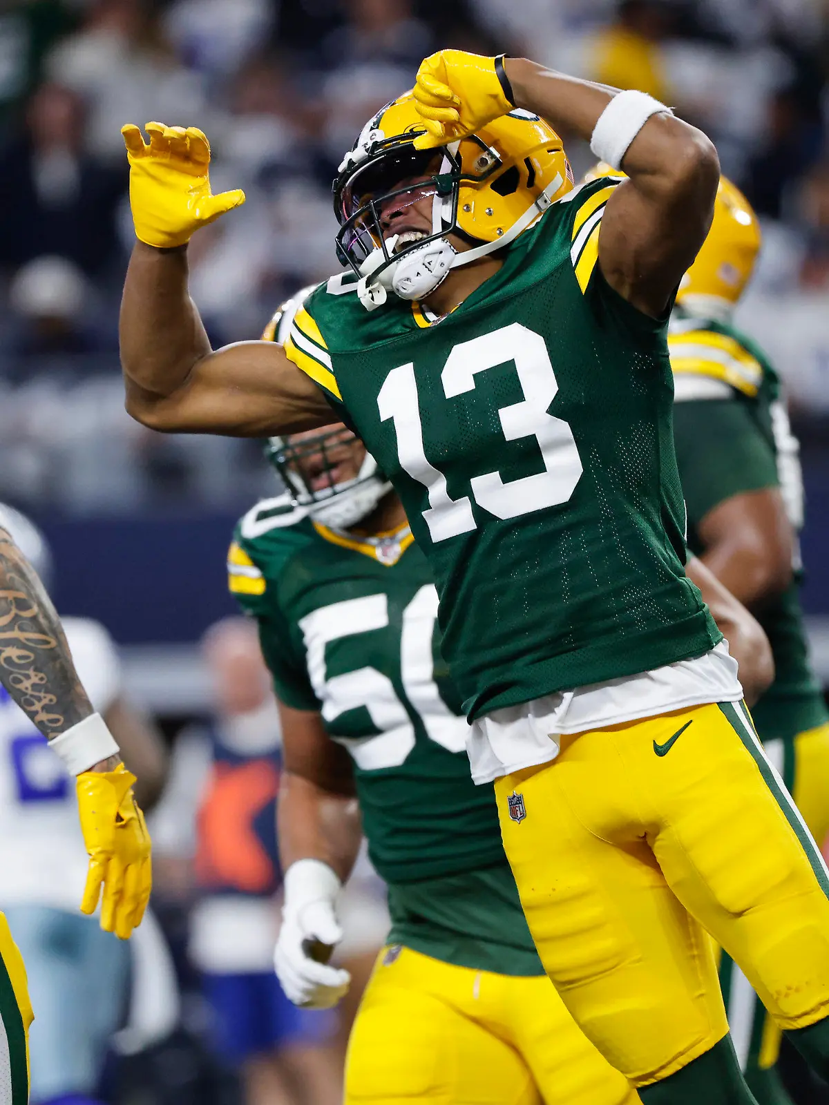 Green Bay Packers wide receiver Dontayvion Wicks (13) celebrates with wide receiver Christian Watson (9) after scoring on a touchdown catch against the Dallas Cowboys during the first half of an NFL football game, Sunday, Jan. 14, 2024, in Arlington, Texas. (AP Photo/Michael Ainsworth)