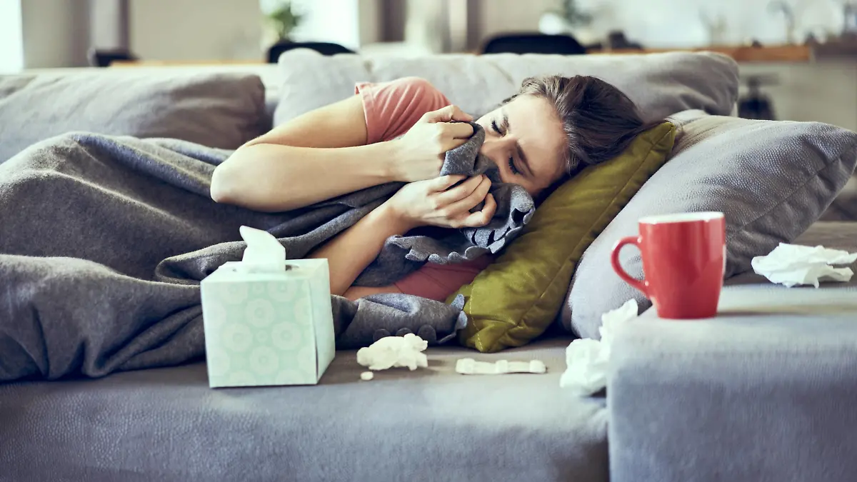  Sick woman trying to take a nap while lying on couch covered in blanket model released Symbolfoto property released PUBLICATIONxINxGERxSUIxAUTxHUNxONLY BSZF00896
