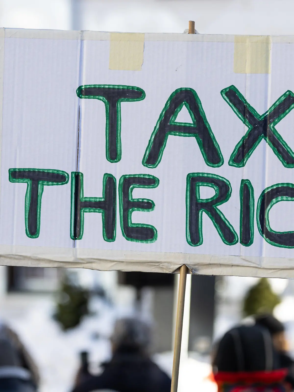 14.01.2024, Schweiz, Davos: Auf einem Schild steht «Tax the richt». Hunderte Menschen demonstrierten für Klimagerechtigkeit unter dem Titel «Strike WEF» in Davos. Die Demonstranten kritisieren dabei das World Economic Forum (WEF) in seiner Rolle und werfen den teilnehmenden Konzernen vor, dass diese aktuelle Krisen anfeuern und davon profitieren. Die Krisen und Kriege der vergangenen Jahre haben die Schere zwischen Arm und Reich auf der Welt noch weiter auseinandergetrieben. Das geht aus einer Studie hervor, die die Entwicklungsorganisation Oxfam vor dem Start des Weltwirtschaftsforums in Davos veröffentlichte. (zu dpa «Oxfam: Superreiche werden trotz Inflation und Krisen noch reicher») Foto: Hannes P. Albert/dpa +++ dpa-Bildfunk +++