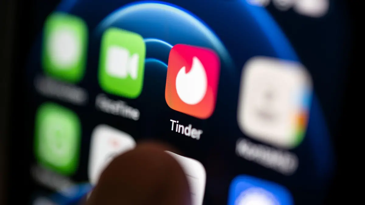 ARCHIV - 02.09.2022, Baden-Württemberg, Stuttgart: Ein Finger bedient ein Smartphone auf dem unter anderen die App von Tinder installiert ist. Tinder und andere Dating-Plattformen des US-Konzerns Match Group ziehen sich aus Russland zurück. (zu dpa: «Dating-App Tinder stellt Betrieb in Russland ein») Foto: Marijan Murat/dpa +++ dpa-Bildfunk +++