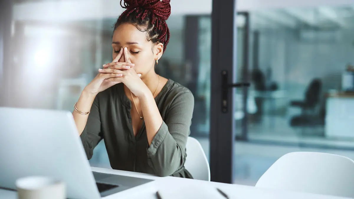 Shot of a young businesswoman looking stressed out while working in an office