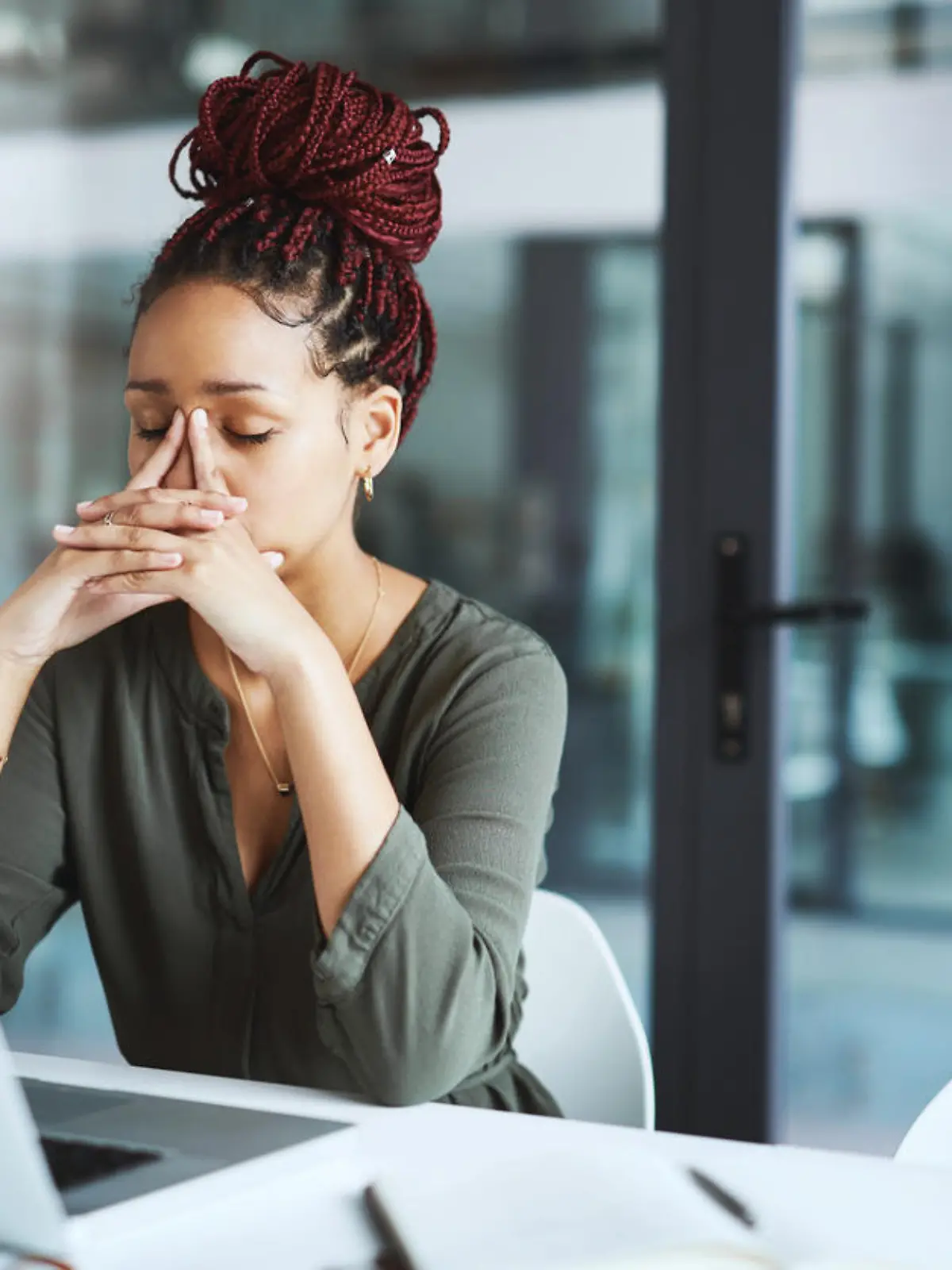 Shot of a young businesswoman looking stressed out while working in an office