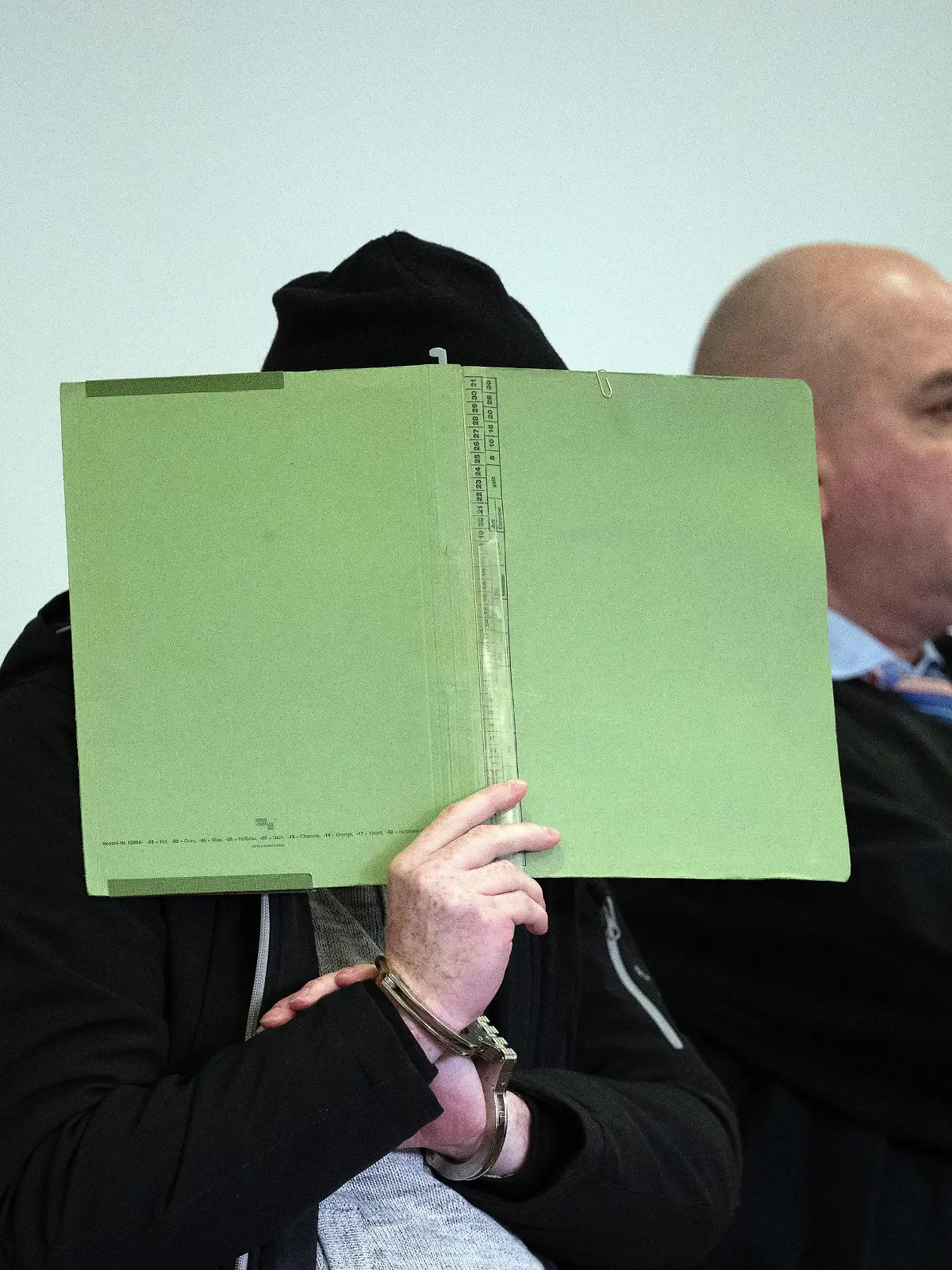 15.01.2024, Brandenburg, Potsdam: Einer der beiden Angeklagten (l) sitzt vor Beginn der Hauptverhandlung im Gerichtssaal 8 des Potsdamer Landgerichts neben seinem Anwalt. Die beiden Angeklagten sollen im Mai 2023 auf der Autobahn A9 zwischen Brück und Beelitz die 40 Jahre alte ehemalige Lebensgefährtin eines Angeklagten mit einer Schusswaffe ermordet haben. Foto: Soeren Stache/dpa +++ dpa-Bildfunk +++