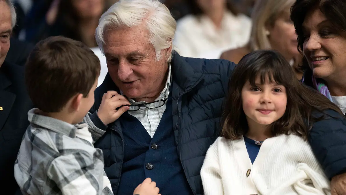 Roberto Canessa, former member of an Uruguayan rugby team who survived a 1972 plane crash in the Chilean Andes, plays with his grandchildren during a Mass in remembrance of the accident in Montevideo, Uruguay, Thursday, Oct. 13, 2022. The former rugby players marked the 50 anniversary of the accident where only 16 of the original 45 passengers aboard survived. (AP Photo/Matilde Campodonico)
