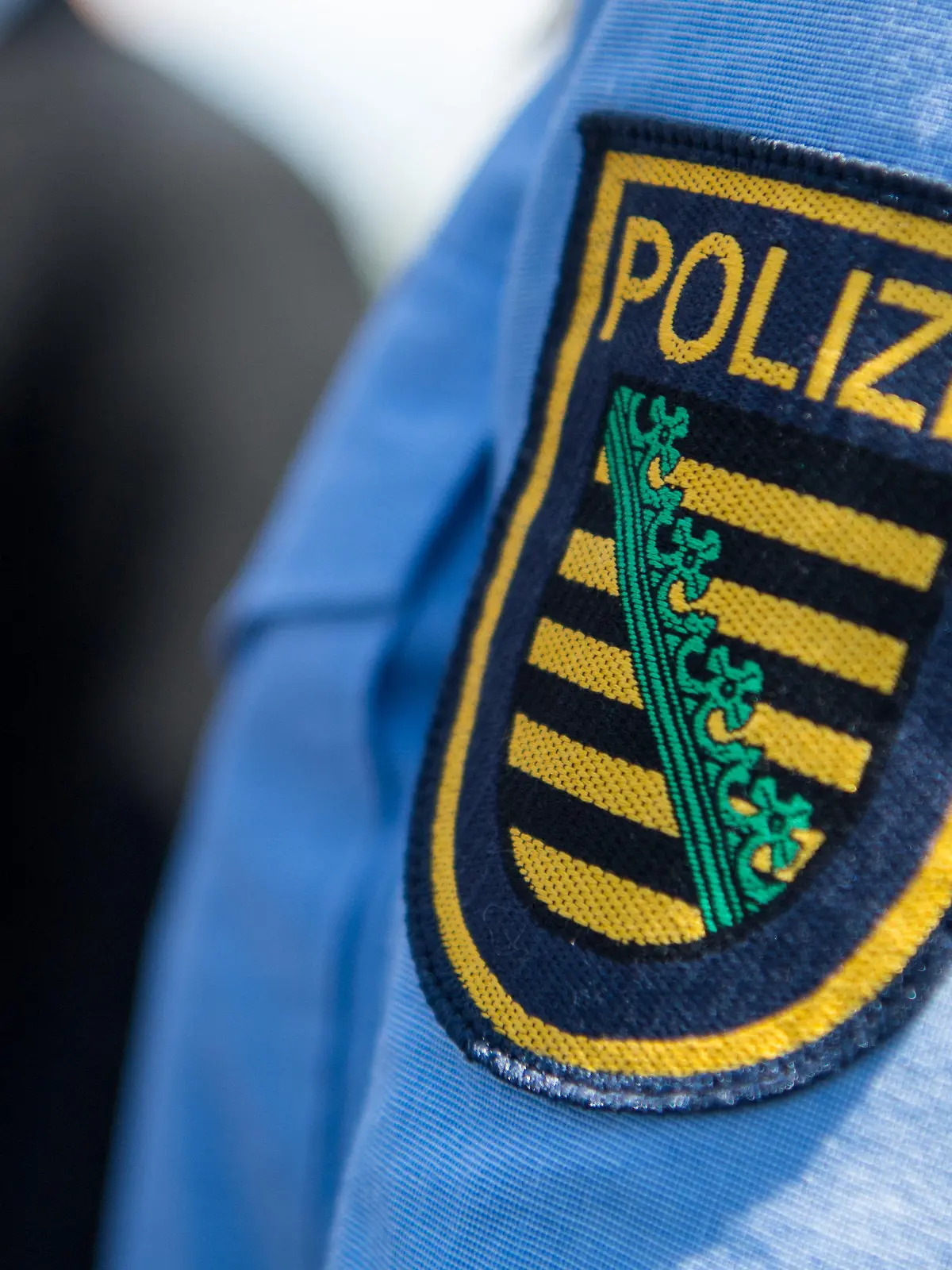 ARCHIV - 28.05.2018, Sachsen, Dresden: Logo der sächsischen Polizei ist an einem Polizeiuniform angebracht. (zu dpa «Diebstahl von Polizei-Munition: Minister Wöller «stinksauer»») Foto: Monika Skolimowska/dpa-Zentralbild/dpa +++ dpa-Bildfunk +++