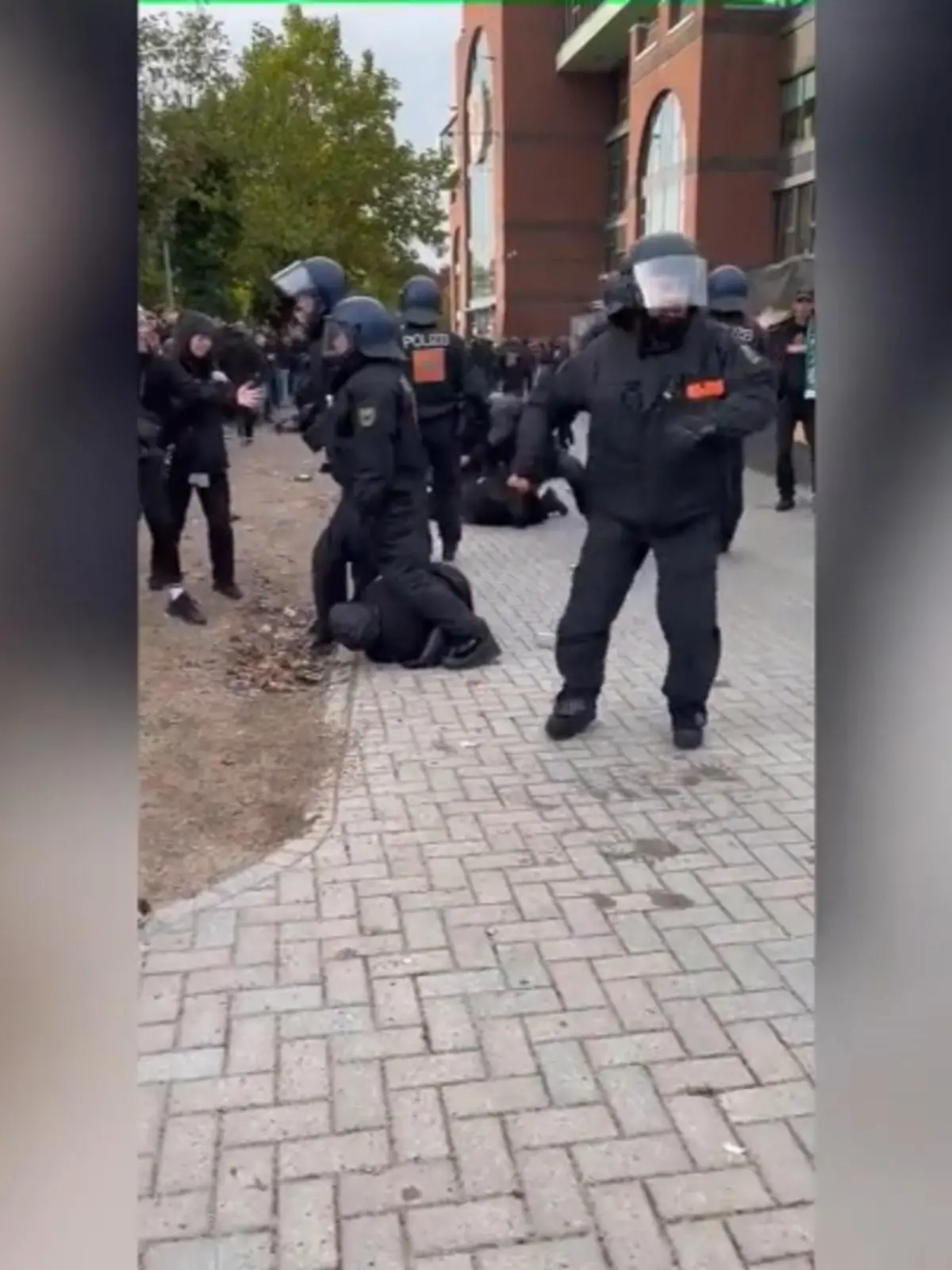 Brutale Szenen aus Hamburg! Ein Polizist (es könnte sich auch um eine PolizistIN handeln) prügelt auf einen am Boden liegenden Mann ein. Erst schlägt die Person in Uniform drei Mal auf die linke Niere, dann noch zwei Mal gegen den Kopf des Mannes. Zu hören ist eine weibliche Stimme: „Bist du nicht ganz dicht oder was?“ Ein Mann ruft: „Seid ihr bescheuert?“