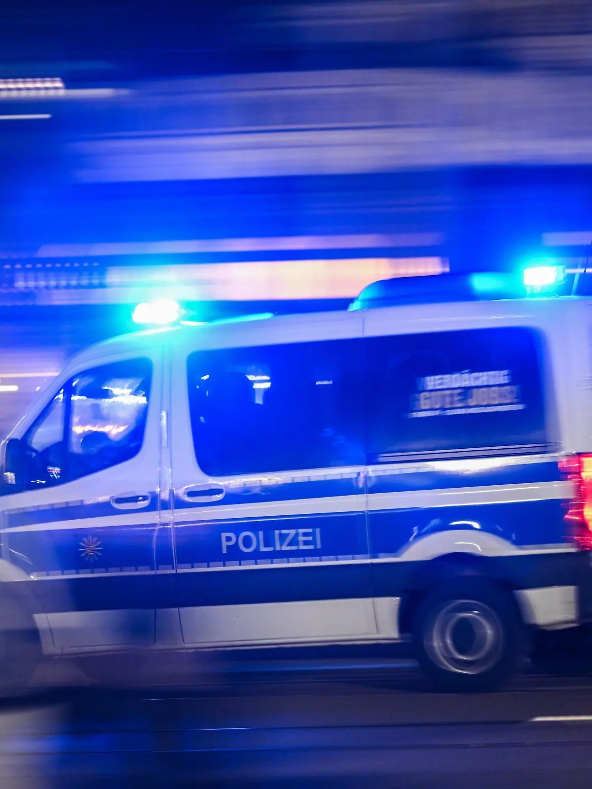 18.12.2023, Sachsen, Dresden: Ein Polizeiauto fährt mit Blaulicht am Rande einer Demonstration der rechtsextremistischen Bewegung Pegida über die Augustusbrücke. Foto: Robert Michael/dpa +++ dpa-Bildfunk +++