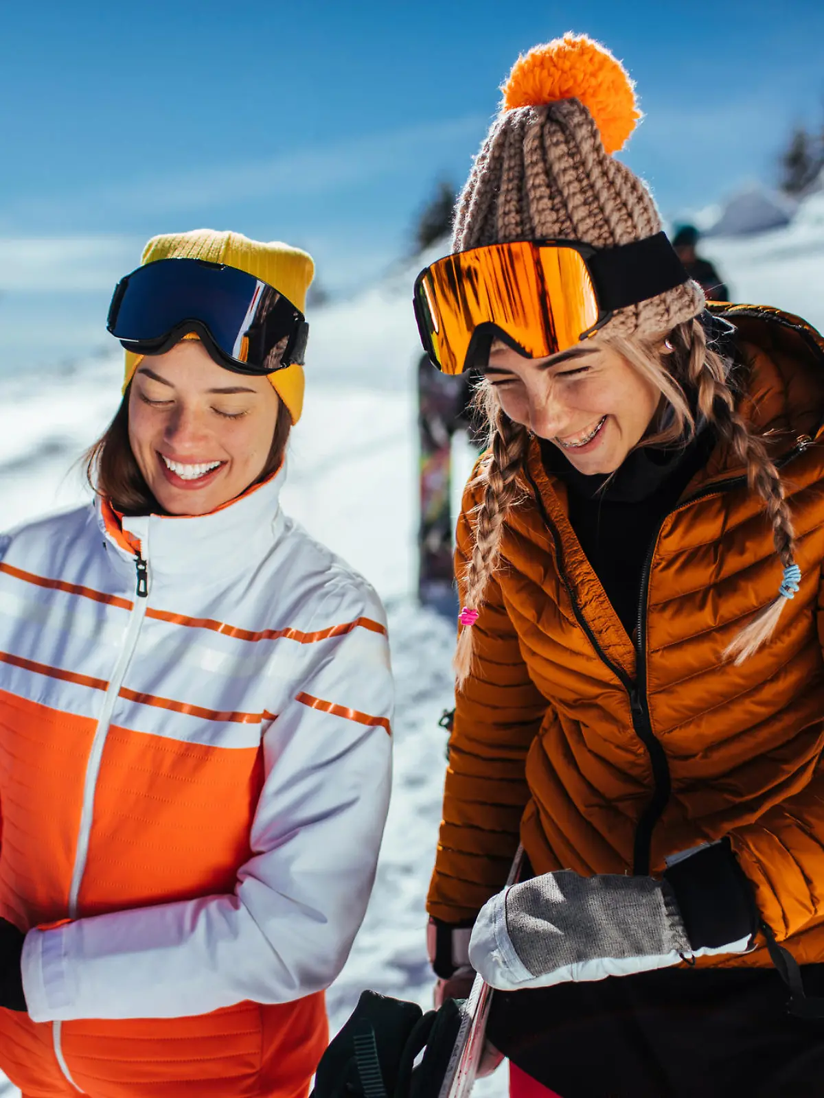 Smiling female friends before a snowboarding session on the mountain