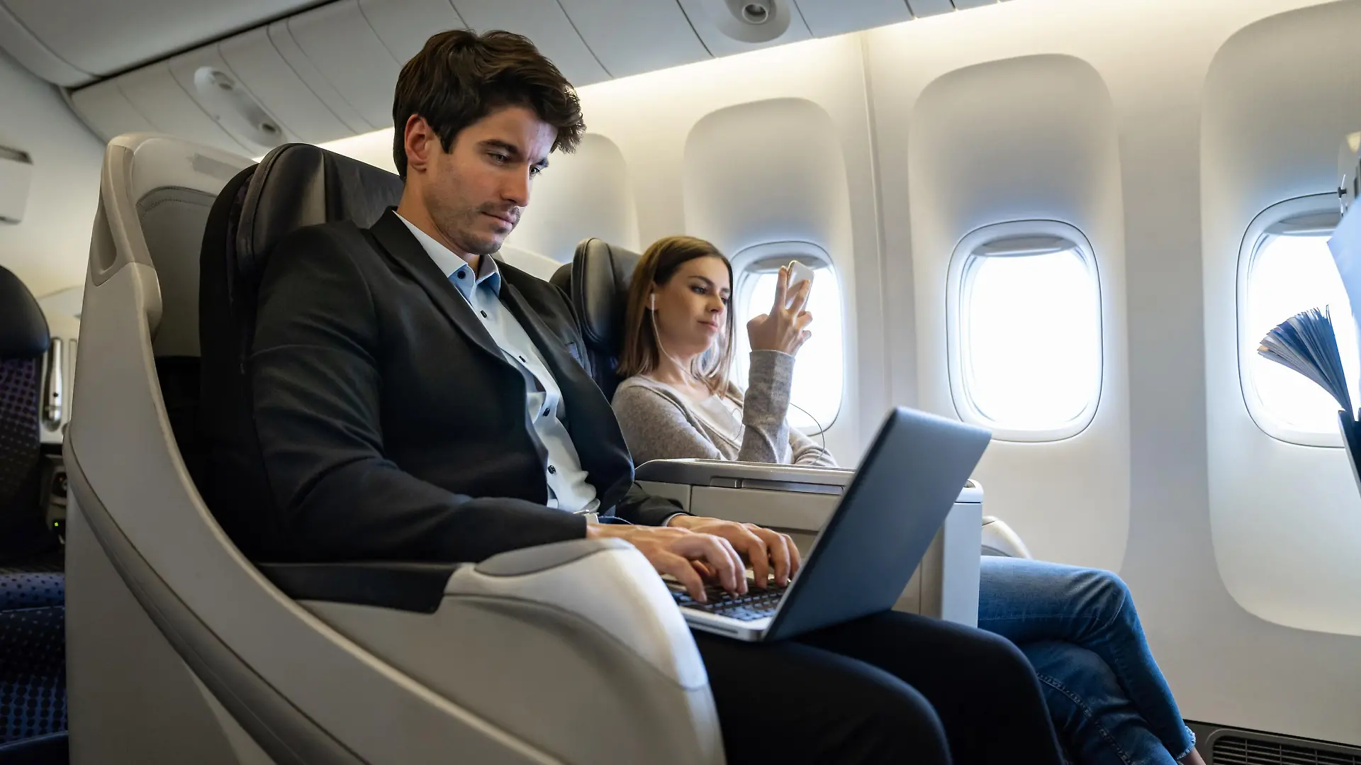Mann in Business Class durch Amex.