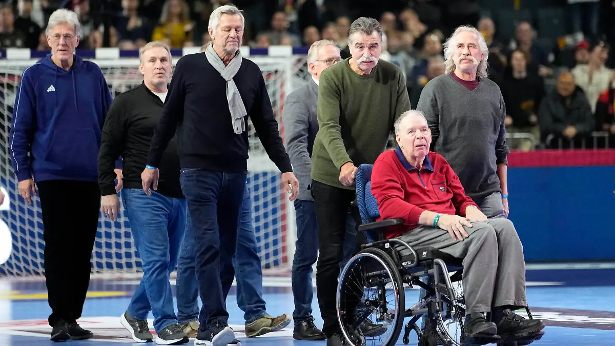 Germany's world handball champions of 1978 with Heiner Brand pushing Joachim Deckarm's wheelchair in front, arrive in the arena prior the Handball European Championship main round match between Germany and Austria in Cologne, Germany, Saturday, Jan. 20, 2024. (AP Photo/Martin Meissner)