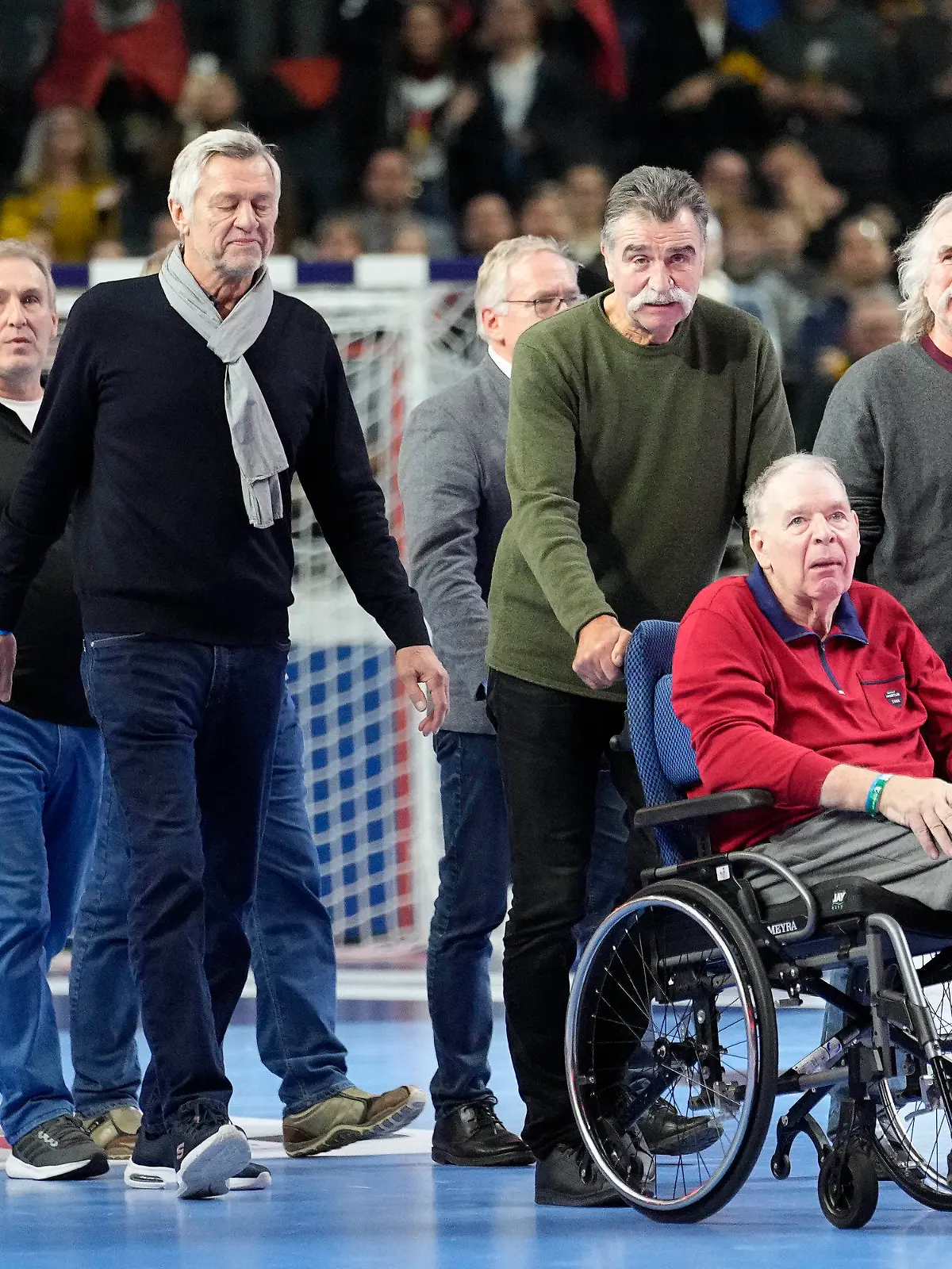 Germany's world handball champions of 1978 with Heiner Brand pushing Joachim Deckarm's wheelchair in front, arrive in the arena prior the Handball European Championship main round match between Germany and Austria in Cologne, Germany, Saturday, Jan. 20, 2024. (AP Photo/Martin Meissner)