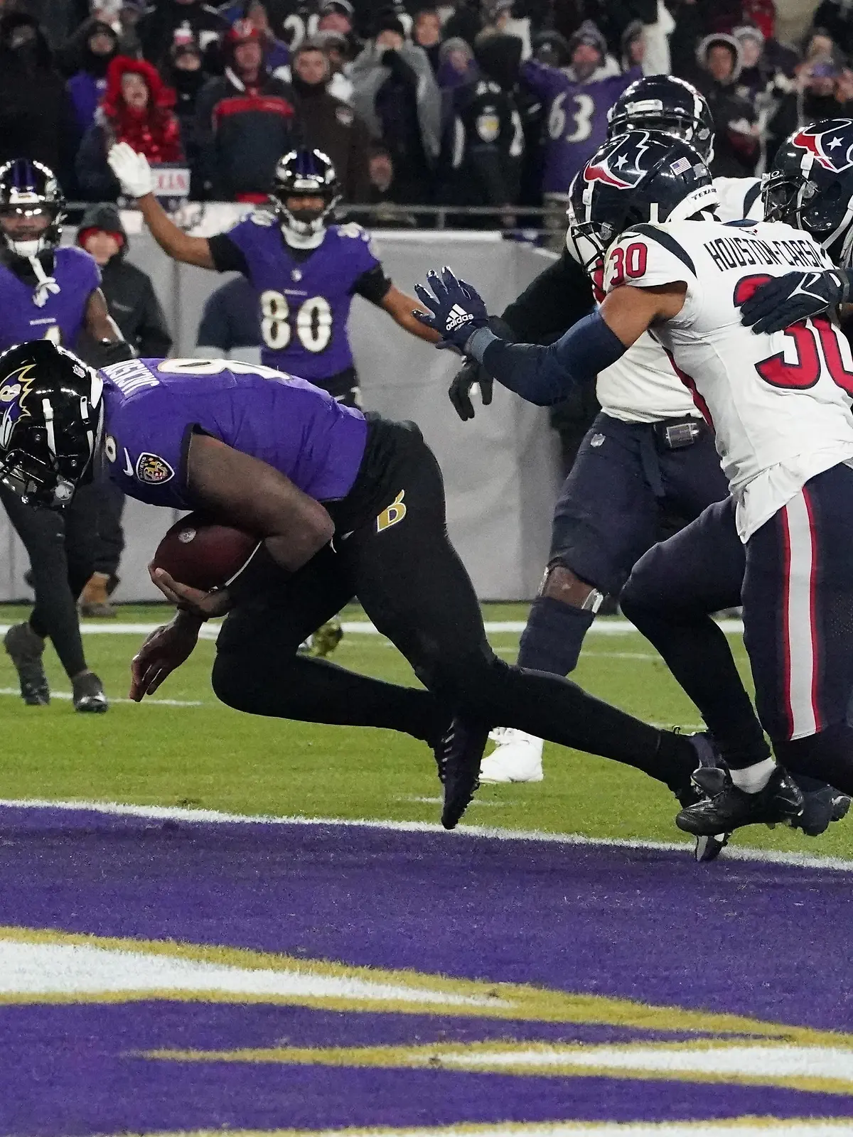 Jan 20, 2024; Baltimore, MD, USA; Baltimore Ravens quarterback Lamar Jackson (8) scores a touchdown against the Houston Texans during the third quarter of a 2024 AFC divisional round game at M&T Bank Stadium. Mandatory Credit: Mitch Stringer-USA TODAY Sports