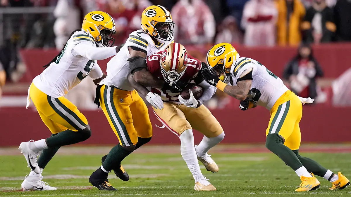 San Francisco 49ers wide receiver Deebo Samuel (19) is tackled by a group of Green Bay Packers defenders during the first half of an NFL football NFC divisional playoff game Saturday, Jan. 20, 2024, in Santa Clara, Calif. (AP Photo/Godofredo A. Vásquez)