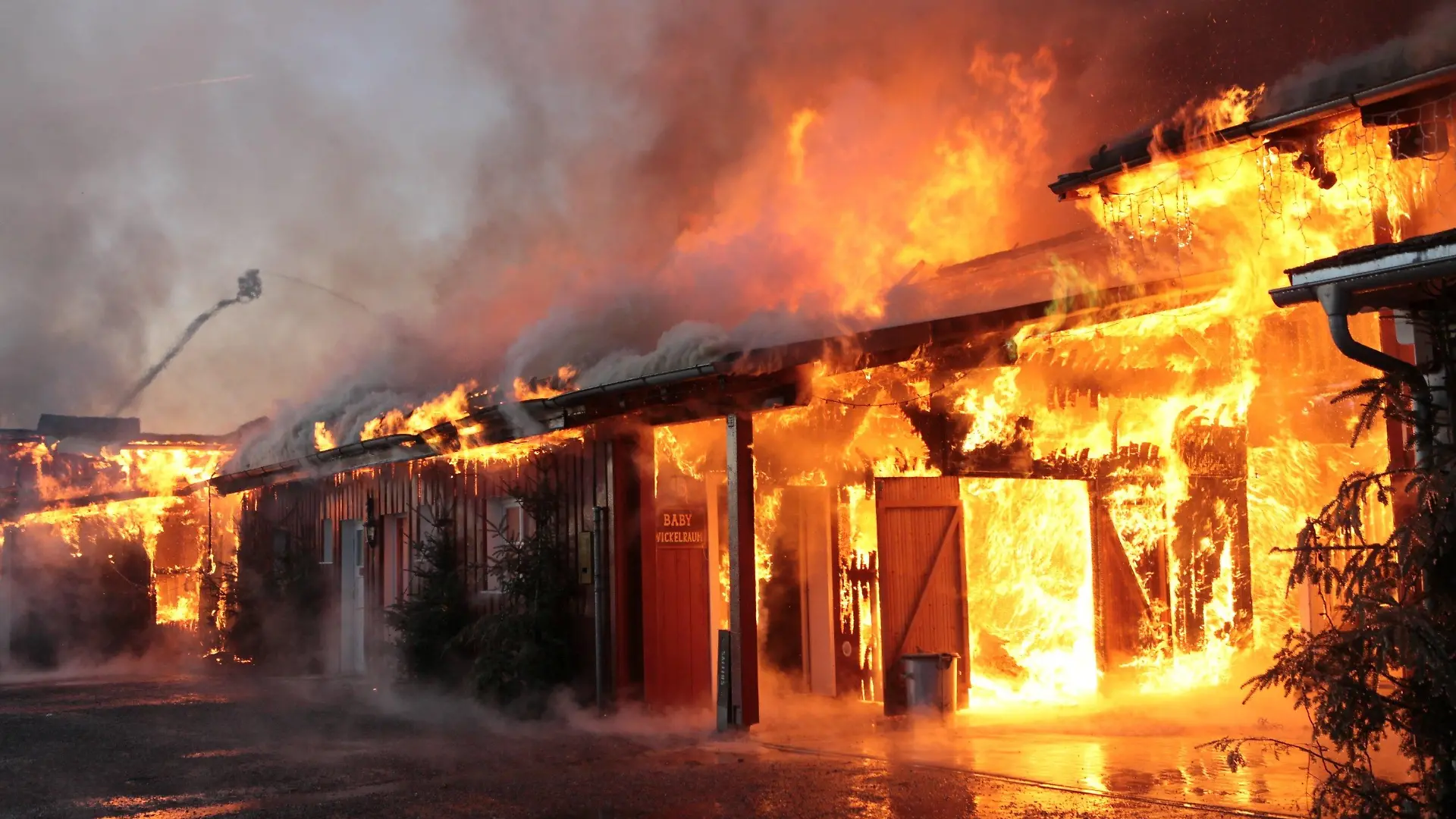 21.01.2024, Bayern, Eging am See: Ein Gebäude in der Westernstadt Pullman City steht in Brand. In dem Freizeitpark Westernstadt Pullman City in Eging am See in Bayern ist am Sonntagmorgen ein Feuer ausgebrochen. Mehrere Gebäude in Holzbauweise wie Saloons stehen entlang der sogenannten Main Street in Vollbrand, wie die Polizei am Sonntagmorgen mitteilte. Die Polizei geht nach ersten Schätzungen von einem Millionenschaden aus. Foto: Lilo Klesse/dpa +++ dpa-Bildfunk +++