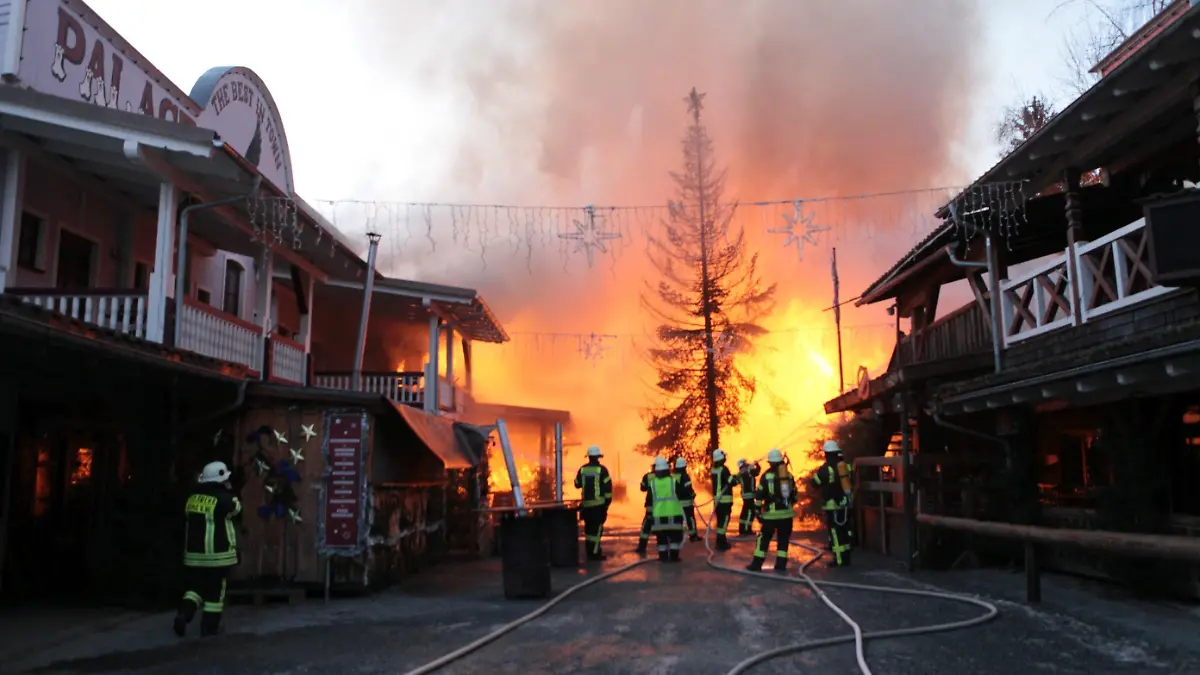 21.01.2024, Bayern, Eging am See: Feuerwehrleute löschen einen Brand in der Westernstadt Pullman City. In dem Freizeitpark Westernstadt Pullman City in Eging am See in Bayern ist am Sonntagmorgen ein Feuer ausgebrochen. Mehrere Gebäude in Holzbauweise wie Saloons stehen entlang der sogenannten Main Street in Vollbrand, wie die Polizei am Sonntagmorgen mitteilte. Die Polizei geht nach ersten Schätzungen von einem Millionenschaden aus. Foto: Lilo Klesse/dpa +++ dpa-Bildfunk +++
