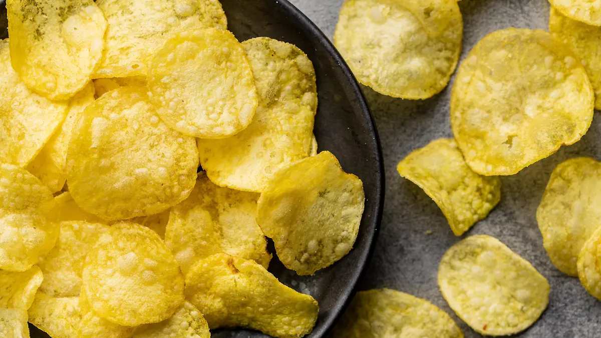 Crunchy potato chips. Potato crisps on plate. Top view.