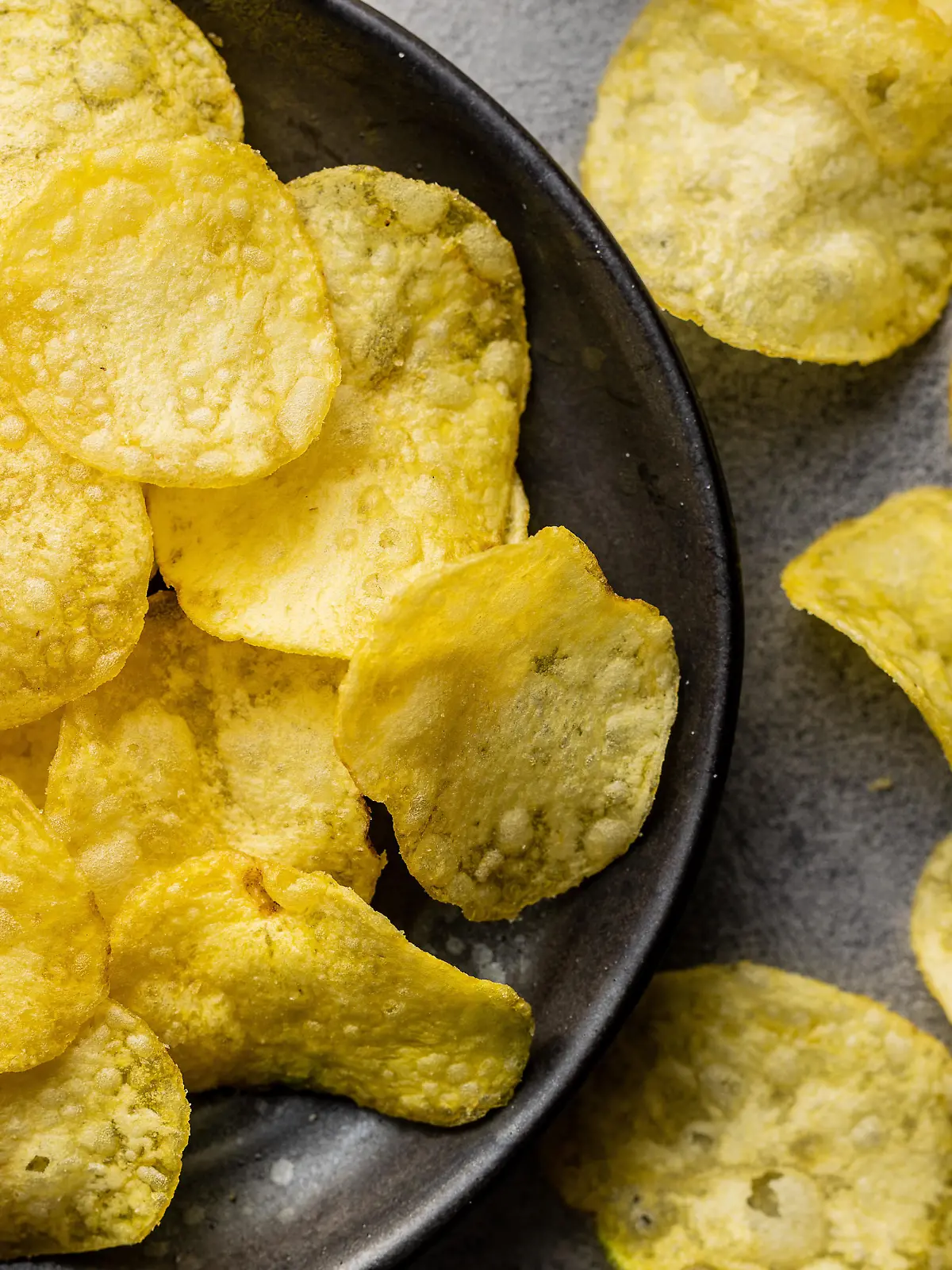 Crunchy potato chips. Potato crisps on plate. Top view.
