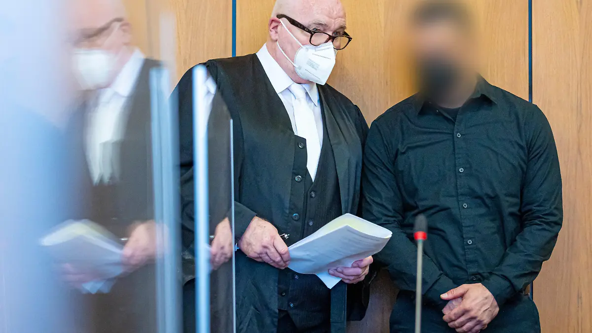 14.10.2022, Niedersachsen, Hildesheim: Der Angeklagte (r) steht bei Prozessauftakt neben seinem Verteidiger Matthias Waldraff in einem Saal vom Landgericht Hildesheim. Dem Angeklagten wird vorgeworfen, im Mai 2022 in Burgdorf (Region Hannover) seine Ehefrau aus niederen Beweggründen heimtückisch ermordet zu haben. Foto: Moritz Frankenberg/dpa - Nutzung nur nach schriftlicher Vereinbarung mit der dpa +++ dpa-Bildfunk +++