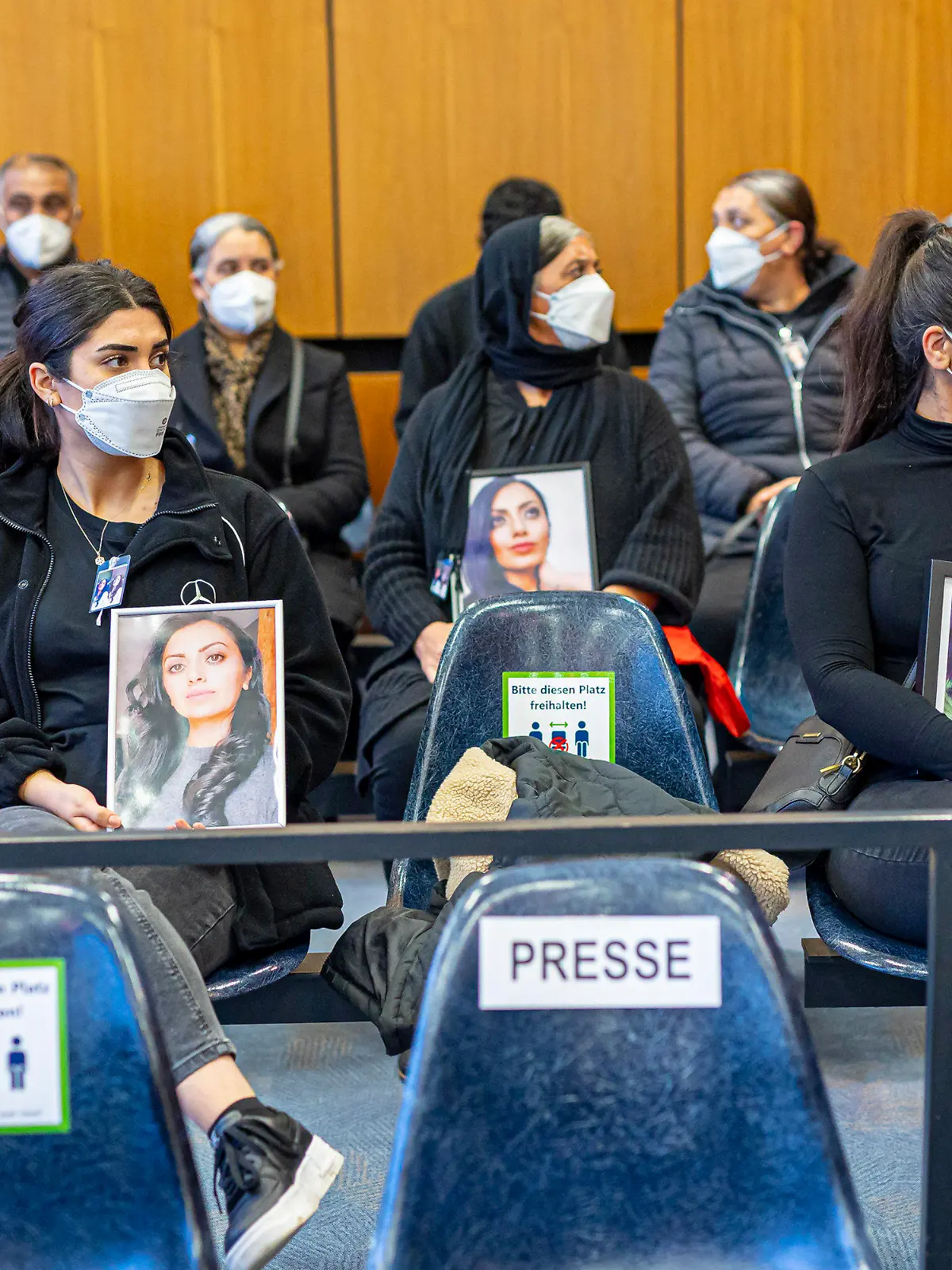 dpatopbilder - 14.10.2022, Niedersachsen, Hildesheim: Angehörige der Getöteten sitzen mit Porträtfotos der Frau bei Prozessauftakt in einem Saal vom Landgericht Hildesheim. Einem Angeklagten wird vorgeworfen, im Mai 2022 in Burgdorf (Region Hannover) seine Ehefrau aus niederen Beweggründen heimtückisch ermordet zu haben. Foto: Moritz Frankenberg/dpa - Nutzung nur nach schriftlicher Vereinbarung mit der dpa +++ dpa-Bildfunk +++