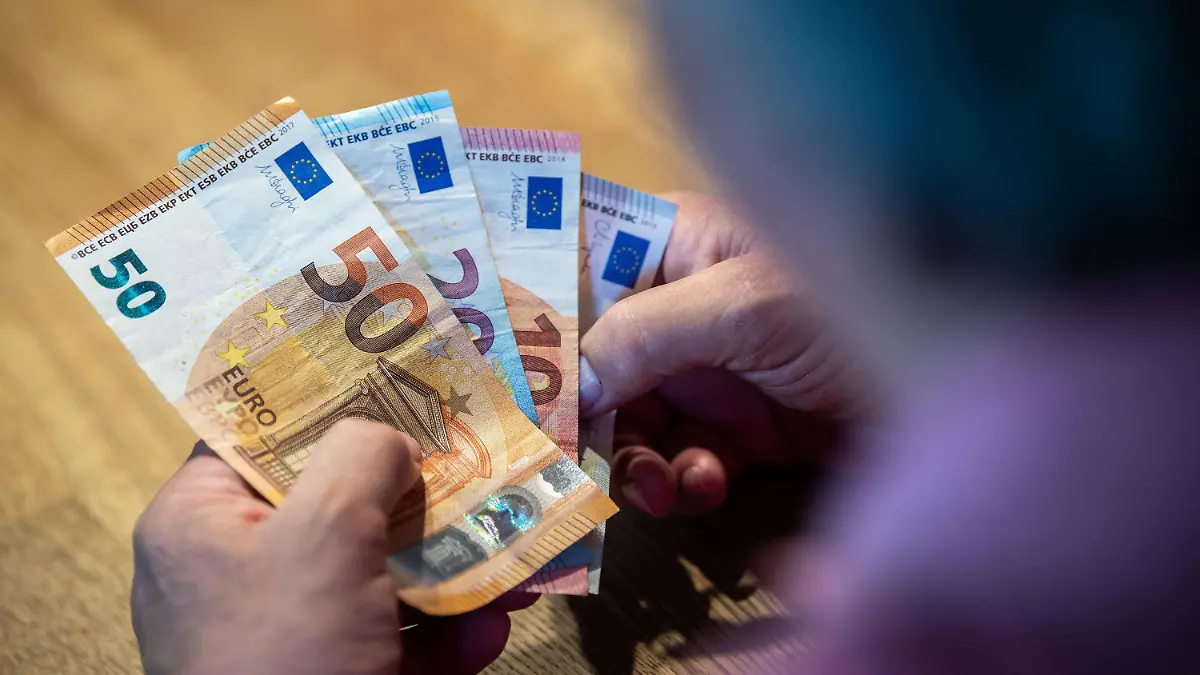 ARCHIV - 11.08.2021, Nordrhein-Westfalen, Bad Oeynhausen: ILLUSTRATION - Ein älterer Mann sitzt an einem Tisch und zählt Geld. Rentnerinnen und Rentner sind nach einer neuen Studie in Ostdeutschland finanziell komfortabler gestellt als im Westen. (Zu dpa: «Studie: Rentner leben im Osten besonders günstig») Foto: Lino Mirgeler/dpa +++ dpa-Bildfunk +++