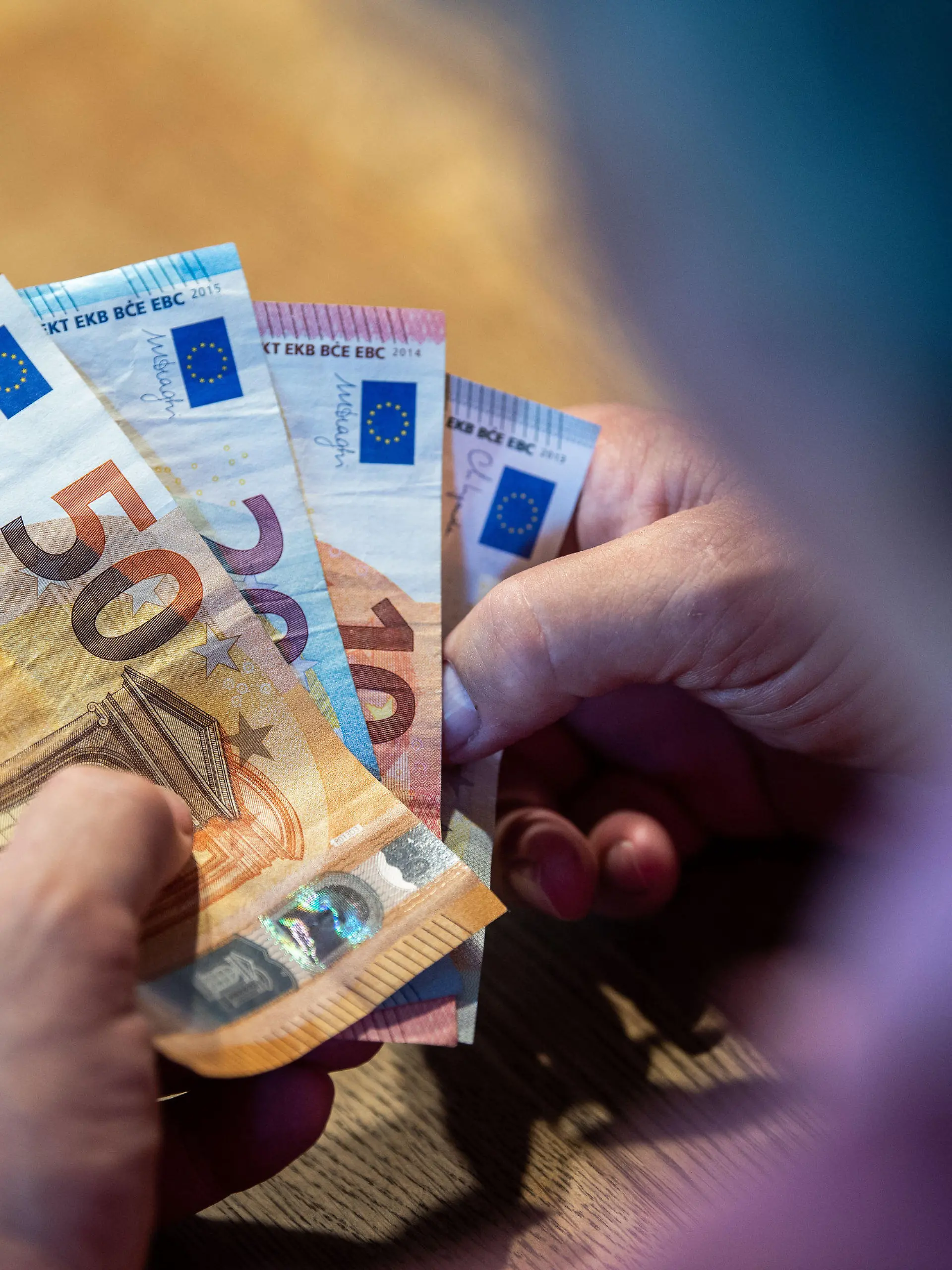ARCHIV - 11.08.2021, Nordrhein-Westfalen, Bad Oeynhausen: ILLUSTRATION - Ein älterer Mann sitzt an einem Tisch und zählt Geld. Rentnerinnen und Rentner sind nach einer neuen Studie in Ostdeutschland finanziell komfortabler gestellt als im Westen. (Zu dpa: «Studie: Rentner leben im Osten besonders günstig») Foto: Lino Mirgeler/dpa +++ dpa-Bildfunk +++
