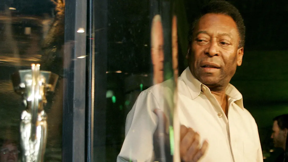 FILE PHOTO: Soccer legend Pele of Brazil and former German player Franz Beckenbauer stand beside a replica of the first World Cup trophy 'Coupe Jule Rimet' during their visit to the exhibition 'Pelestation' in Berlin, Germany June 29, 2006. REUTERS/Arnd Wiegmann/File Photo
