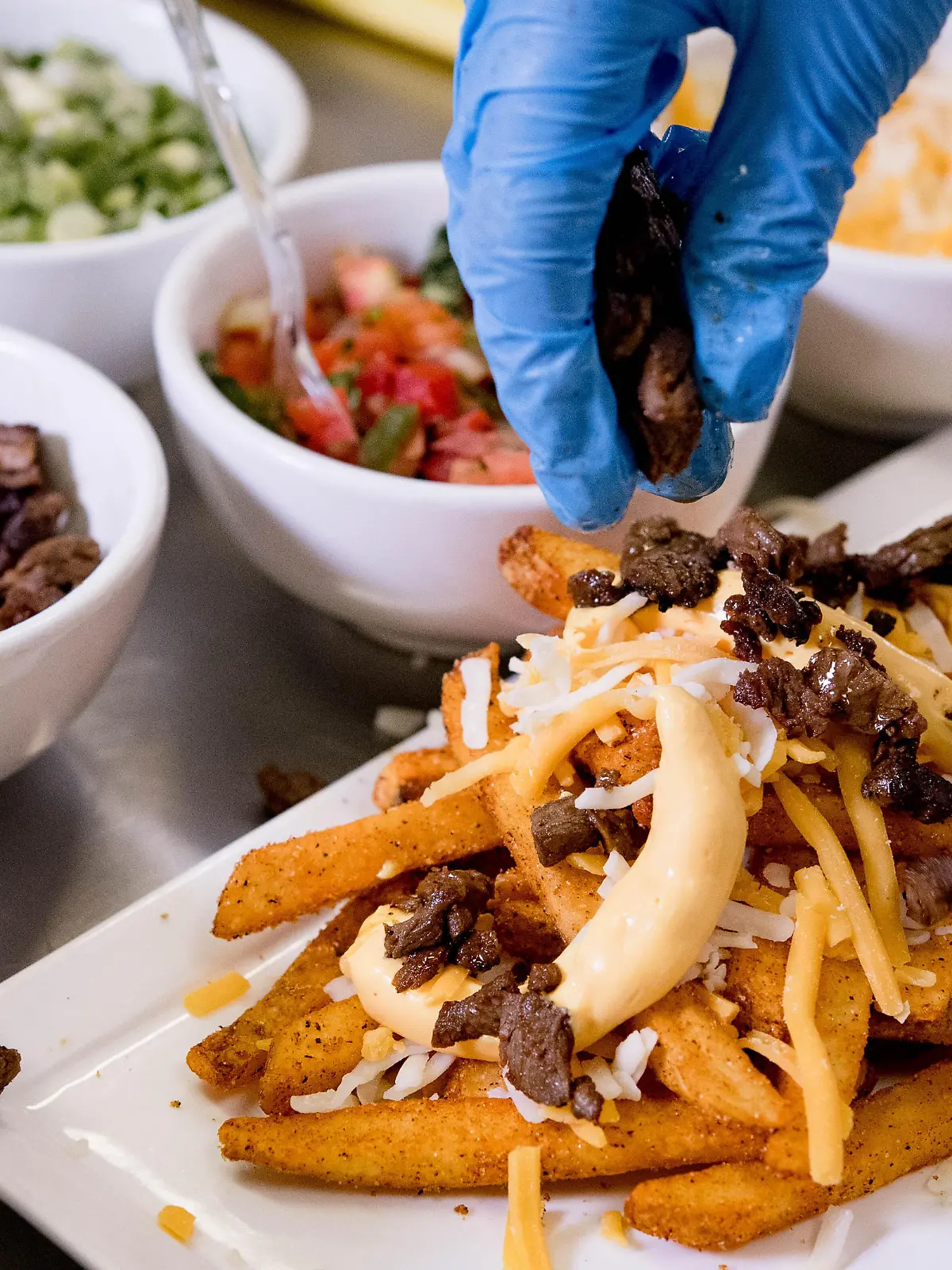 October 16, 2019, Temecula, California, USA: Culinary student Spencer Paredes meticulously garnishes steak onto a surf 'n turf fries dish during a demonstration at Temecula Valley High School in Temecula on Wednesday, Oct. 16, 2019. The culinary students will team with Pechanga chefs to compete for best loaded fries at the 2019 Battle of the Burgers competition at Pechanga Resort Casino this Saturday. (Credit Image: © Watchara Phomicinda/Orange County Register via ZUMA Wire