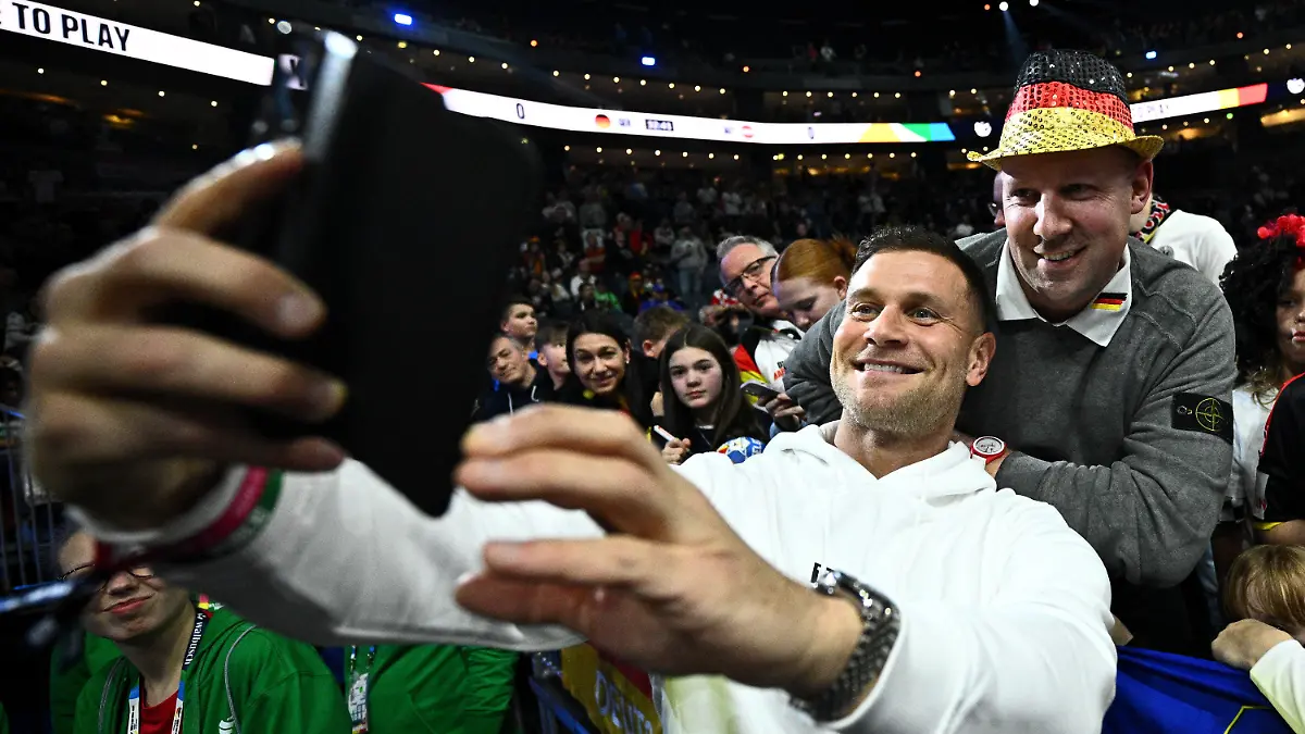 20.01.2024, Nordrhein-Westfalen, Köln: Handball: EM, Deutschland - Österreich, Hauptrunde, Gruppe 1, 2. Spieltag, Lanxess Arena. Michael Mimi Kraus macht vor dem Spiel mit Fans ein Selfie. Foto: Tom Weller/dpa +++ dpa-Bildfunk +++