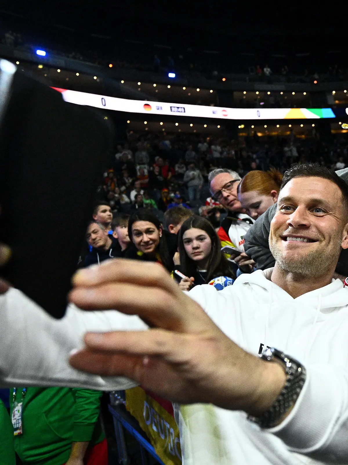 20.01.2024, Nordrhein-Westfalen, Köln: Handball: EM, Deutschland - Österreich, Hauptrunde, Gruppe 1, 2. Spieltag, Lanxess Arena. Michael Mimi Kraus macht vor dem Spiel mit Fans ein Selfie. Foto: Tom Weller/dpa +++ dpa-Bildfunk +++