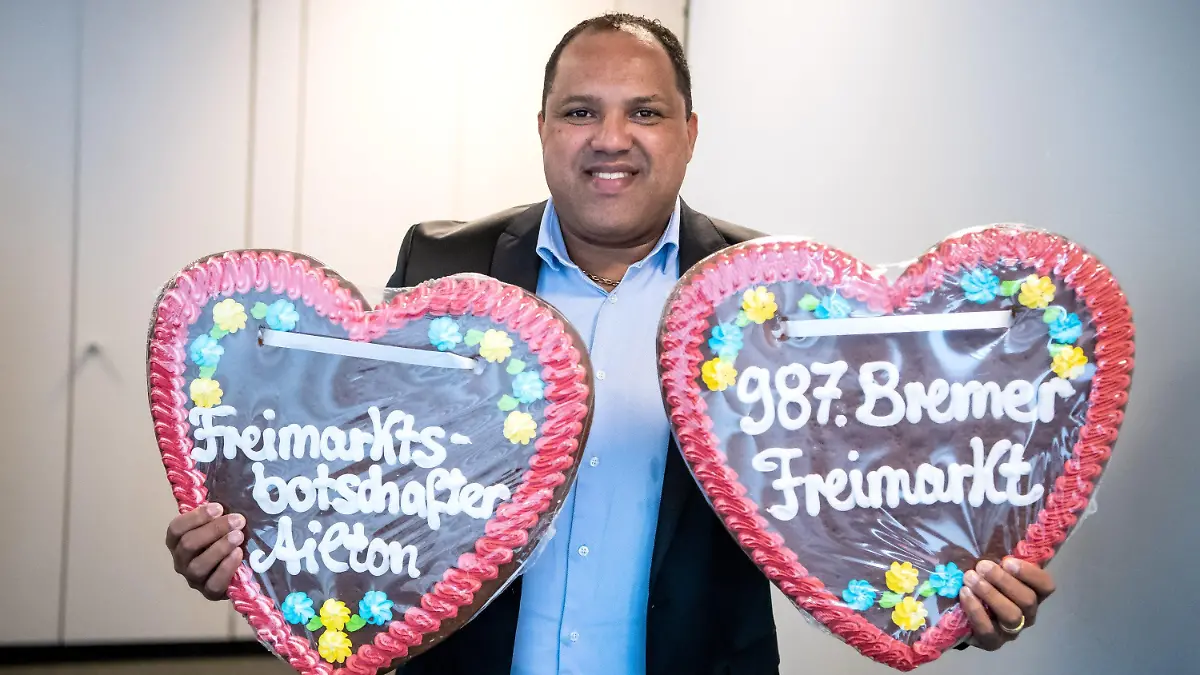 23.09.2022, Bremen: Ailton hält zwei große Lebkuchenherzen. Der Ex-Fußballer Ailton übernimmt die Botschafterrolle für den 987. Bremer Freimarkt. Foto: Sina Schuldt/dpa +++ dpa-Bildfunk +++