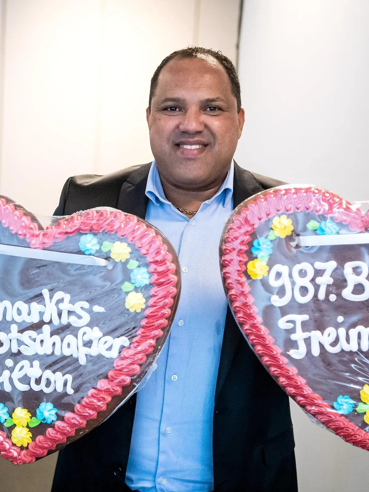 23.09.2022, Bremen: Ailton hält zwei große Lebkuchenherzen. Der Ex-Fußballer Ailton übernimmt die Botschafterrolle für den 987. Bremer Freimarkt. Foto: Sina Schuldt/dpa +++ dpa-Bildfunk +++