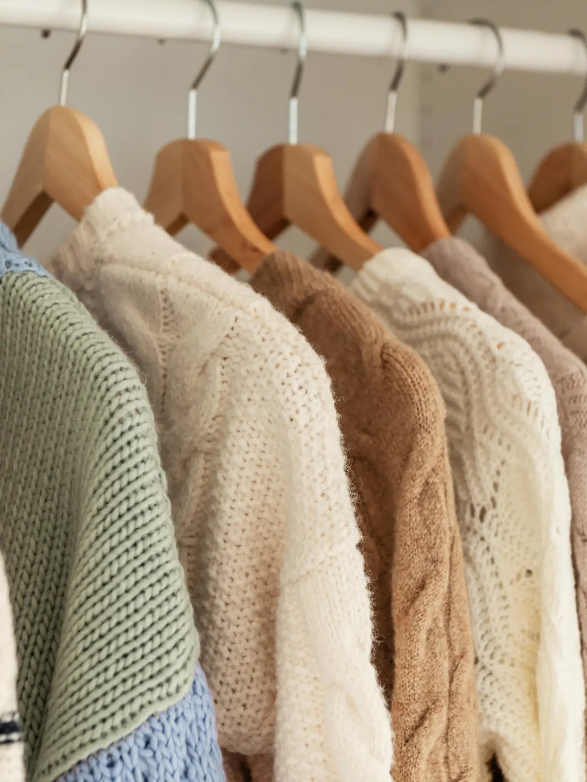 Warm winter beige wool pullover and knitwear and hanging in wardrobe