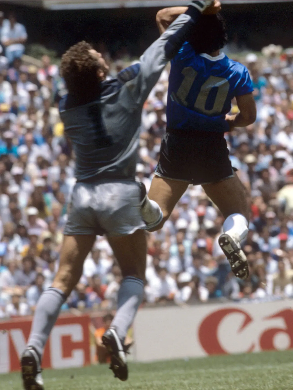 ARCHIV - 22.06.1986, Mexiko, Mexiko-Stadt: Es stehen sich am 22. Juni 1986, dem Viertelfinalspiel der Weltmeisterschaft 1986 in Mexiko, Argentinien und England gegenüber. Das Spiel endete 2:1 für Argentinien. Der Argentinier Diego Maradona (r) erzielt das Tor mit der «Hand Gottes» gegen den englischen Tormann Peter Shilton. (zu dpa ««Hand Gottes»: Maradonas WM-Trikot von 1986 wird versteigert») Foto: -/dpa +++ dpa-Bildfunk +++