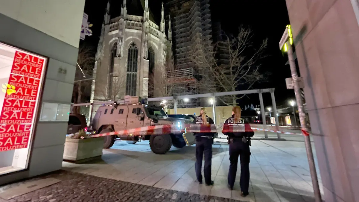 26.01.2024, Baden-Württemberg, Ulm: Zwei Polizistinnen stehen hinter einem Absperrband der Polizei am Münsterplatz. Die Polizei hat wegen eines Einsatzes am Freitagabend Teile des zentralen Münsterplatzes in Ulm gesperrt. Foto: Nico Pointner/dpa +++ dpa-Bildfunk +++