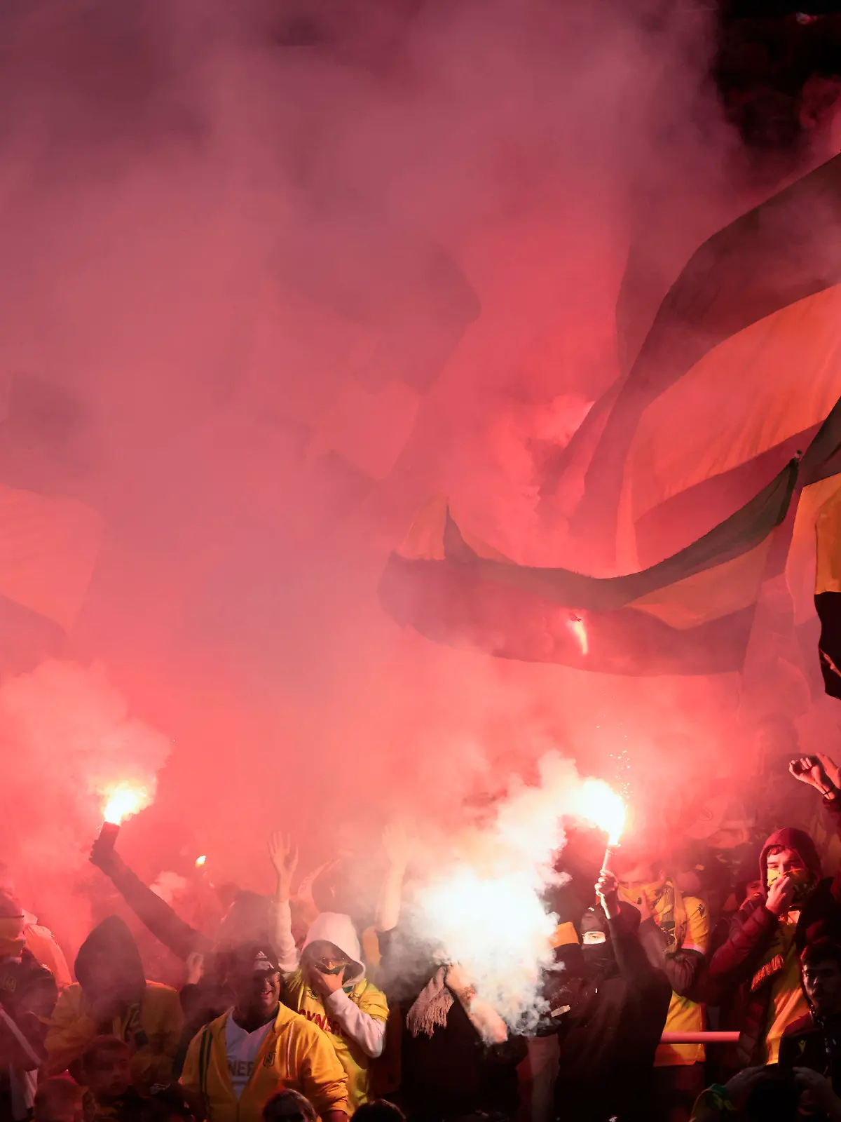 Nantes supporters burn flares and hold flags during the Europa League soccer match between Nantes and SC Freiburg at the Stade de la Beaujoire in Nantes, western France, Thursday, Oct. 13, 2022. (AP Photo/Jeremias Gonzalez)